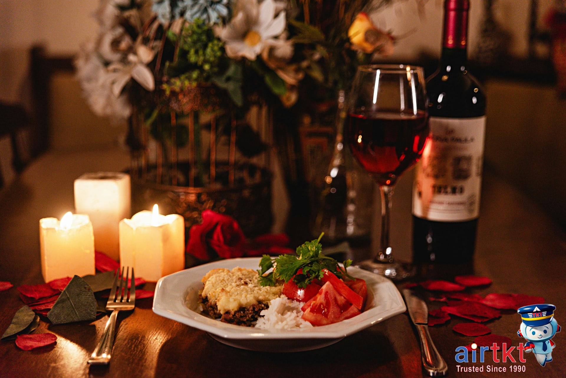 Romantic candlelit dinner for Mother's Day weekend with wine and rose petals on table