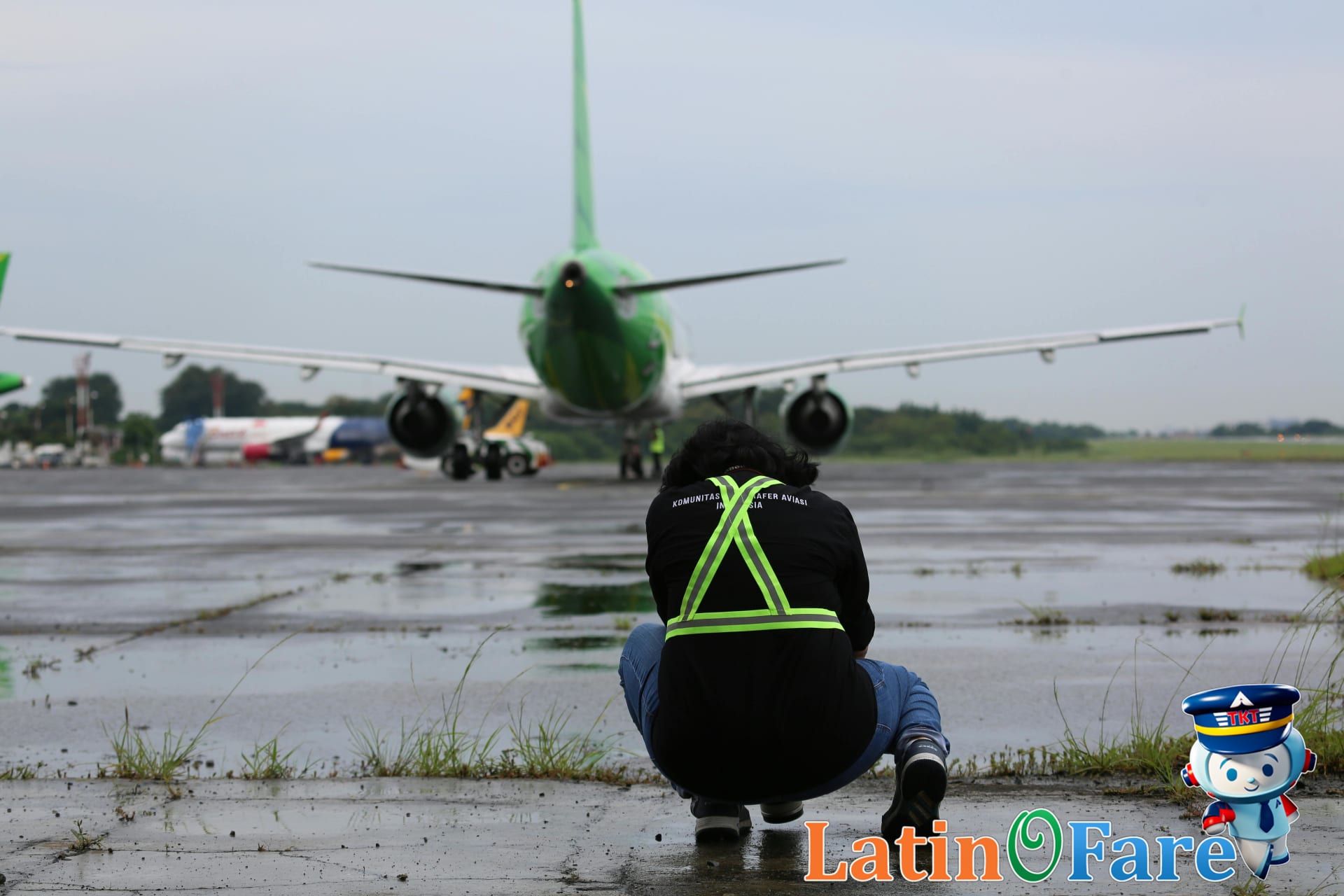 Budget airline staff preparing plane for cheap intra-Asia flight at busy Bangkok airport.