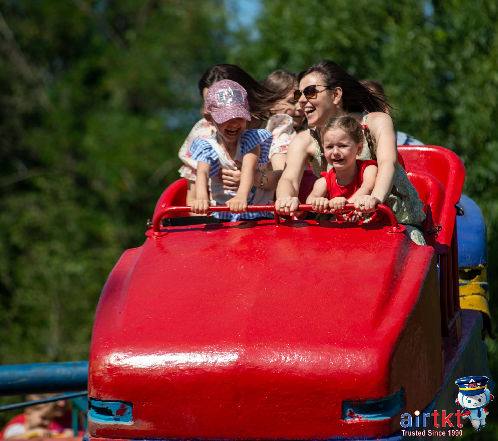 Family exploring an enjoyable theme park with kids and parents near colorful rides