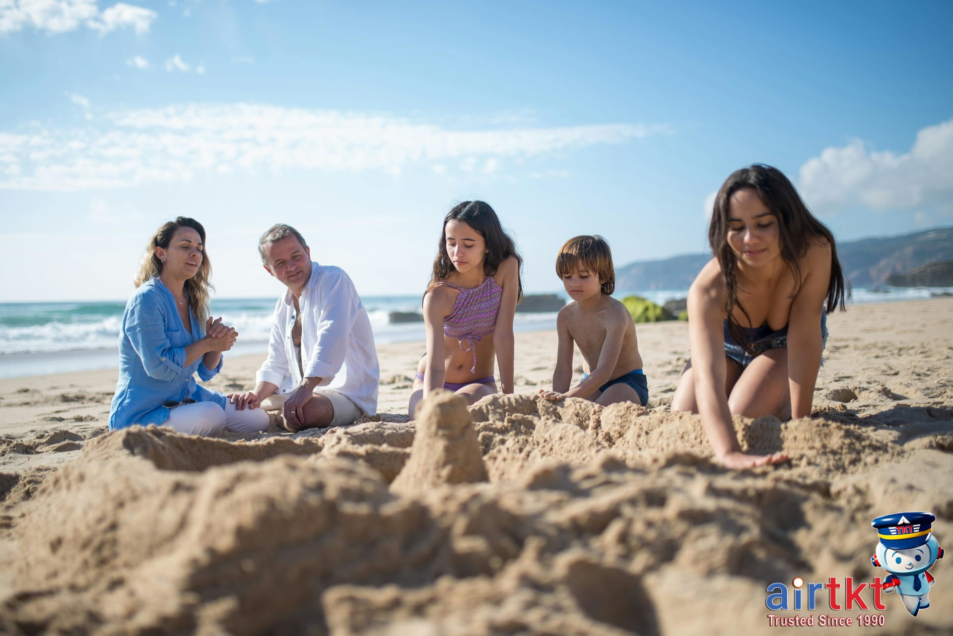 Children building sandcastles on a calm beach for family vacation fun