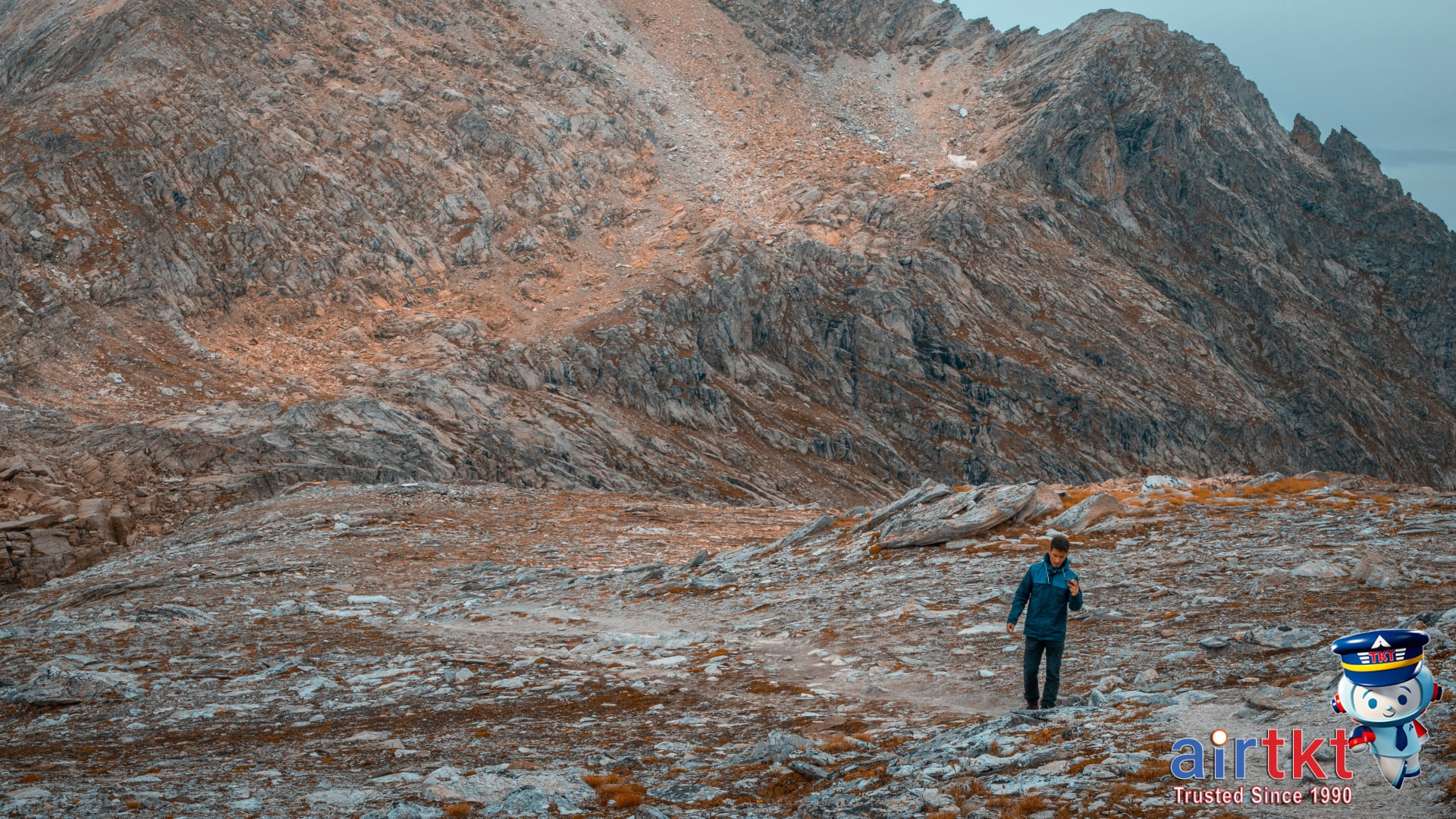 Hiker trekking on rugged mountain trail surrounded by rocky peaks near Denver