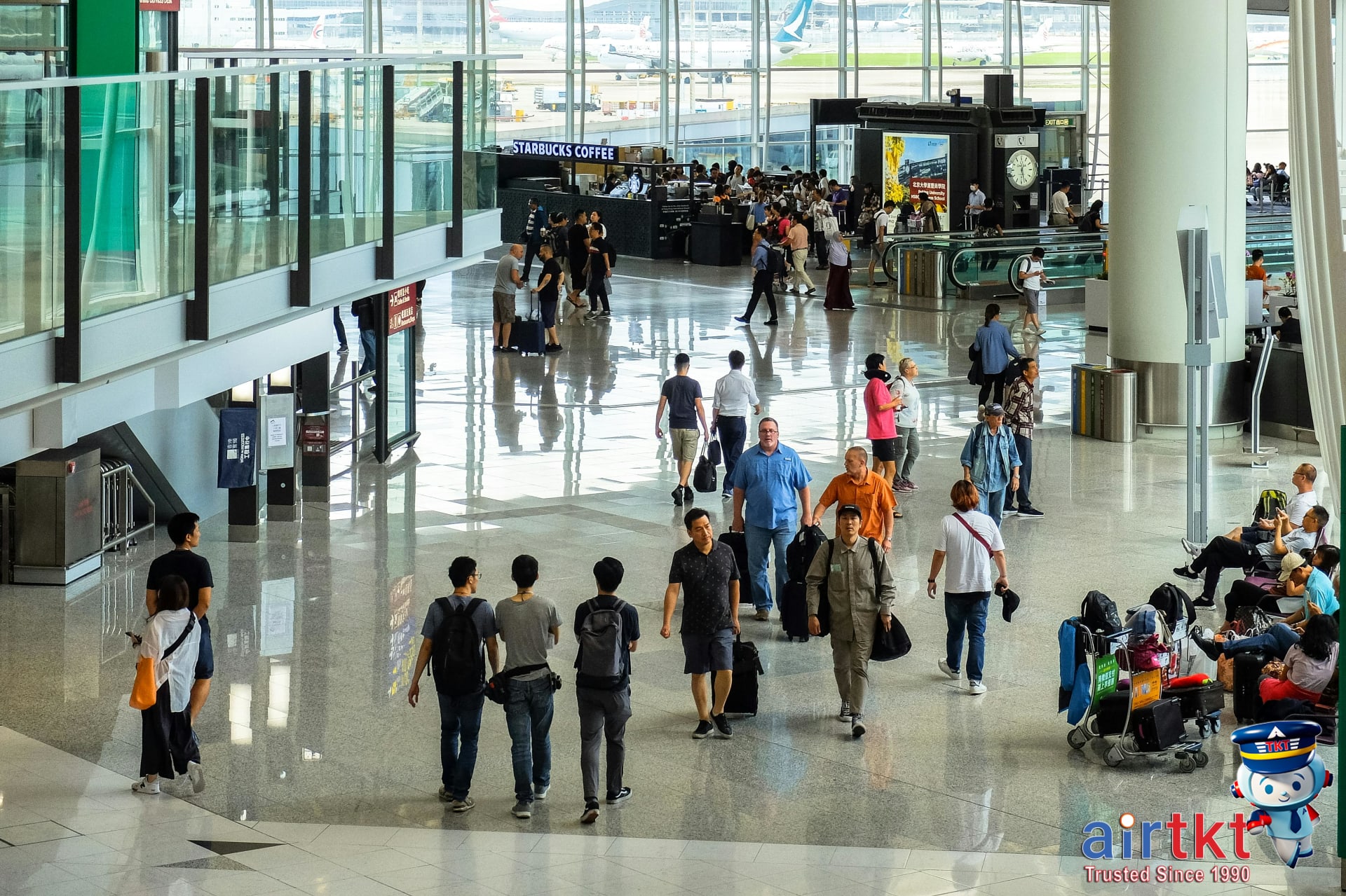 Travelers at Asian airport terminal on budget airlines with diverse passengers