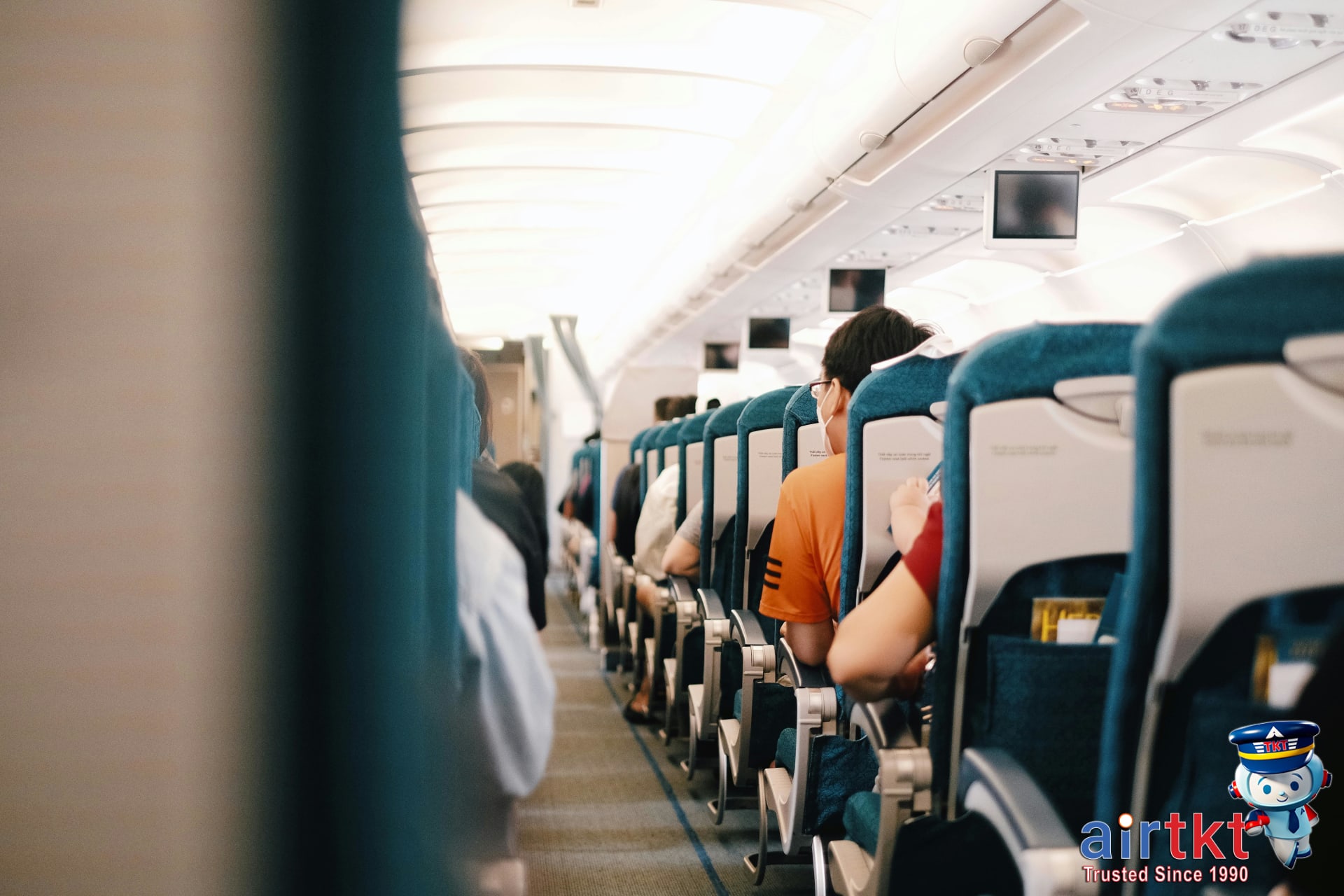 Economy cabin interior on budget Asian airline showing seats and passengers