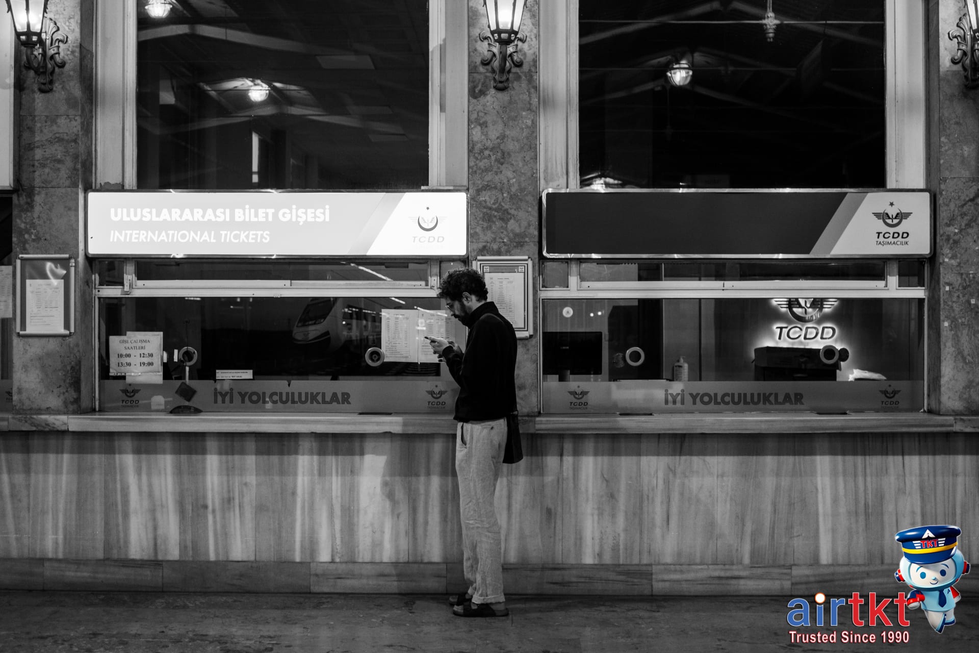 Person booking Amtrak tickets online with travel guides nearby