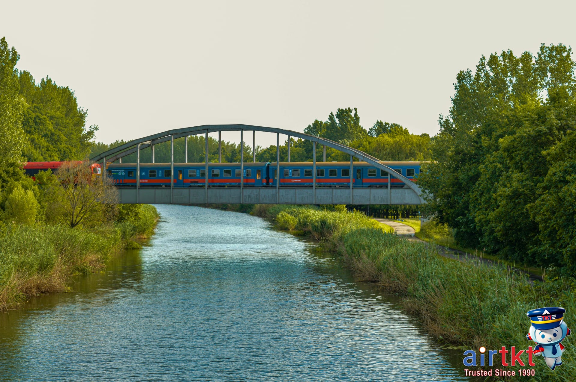 Amtrak train crossing scenic U.S. countryside bridge over a river