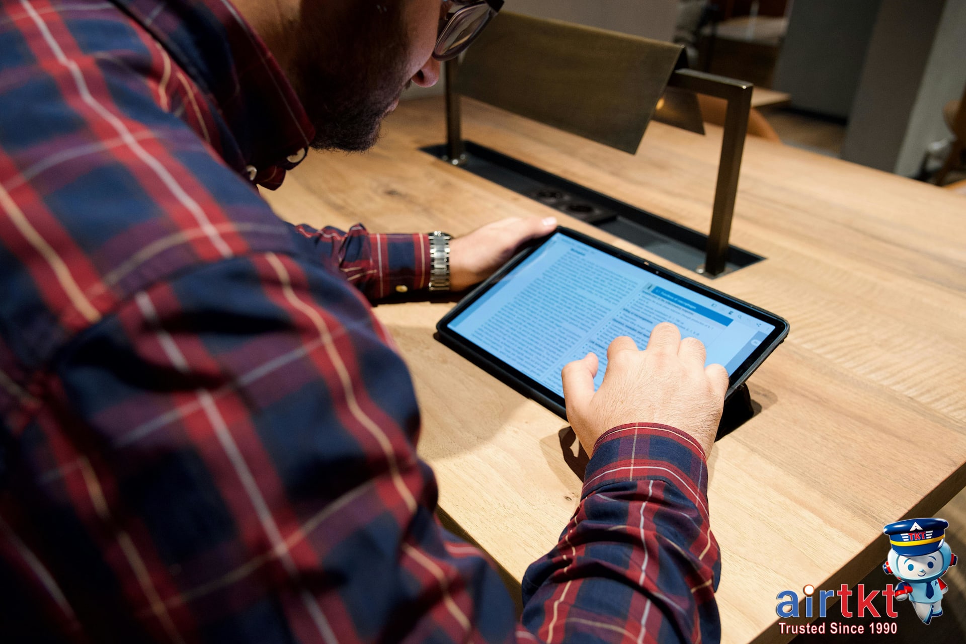 Traveler reading frequently asked questions about flight booking on tablet