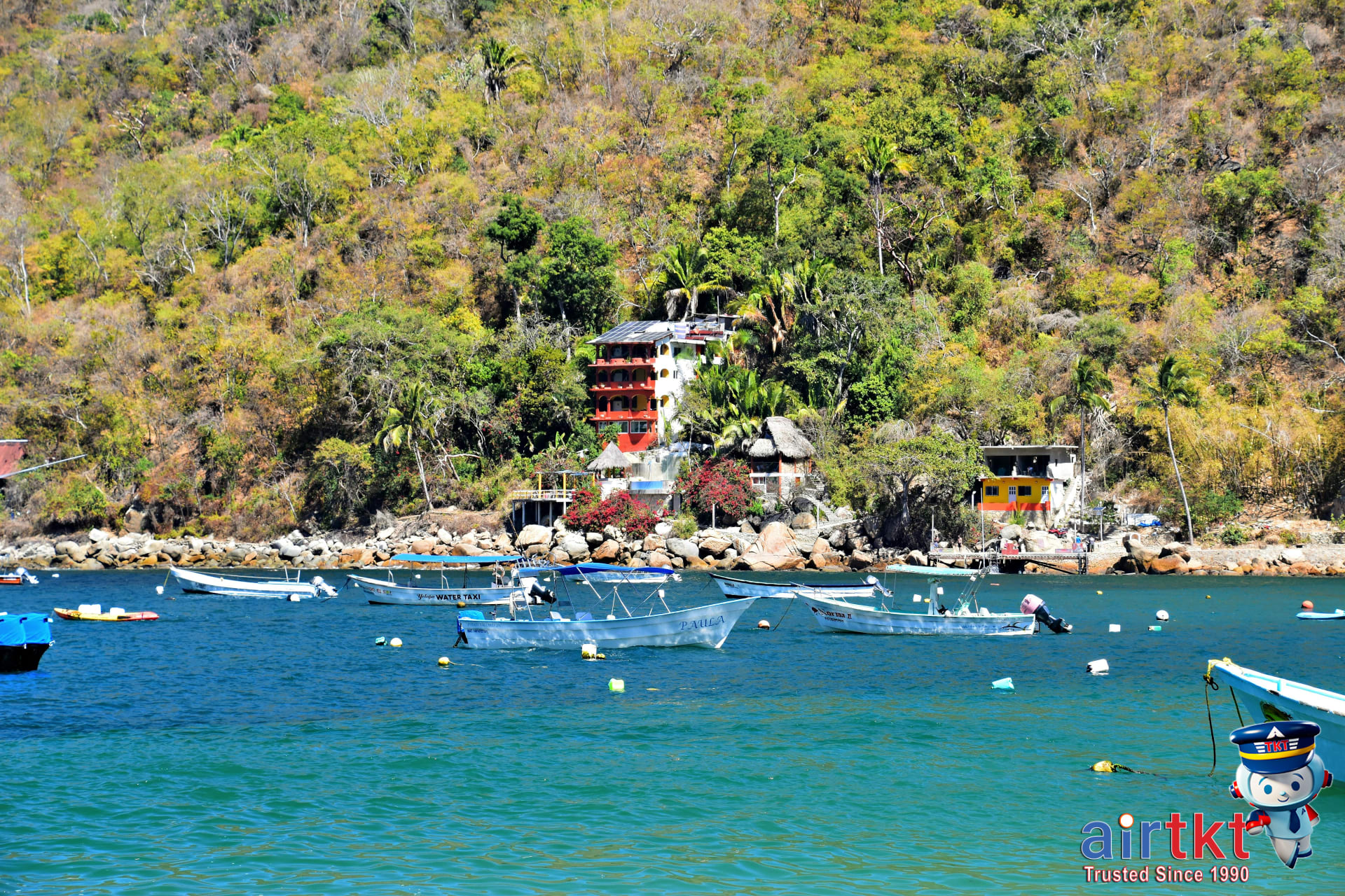 Fishing boats at coastal village Barra de Navidad with hillside backdrop