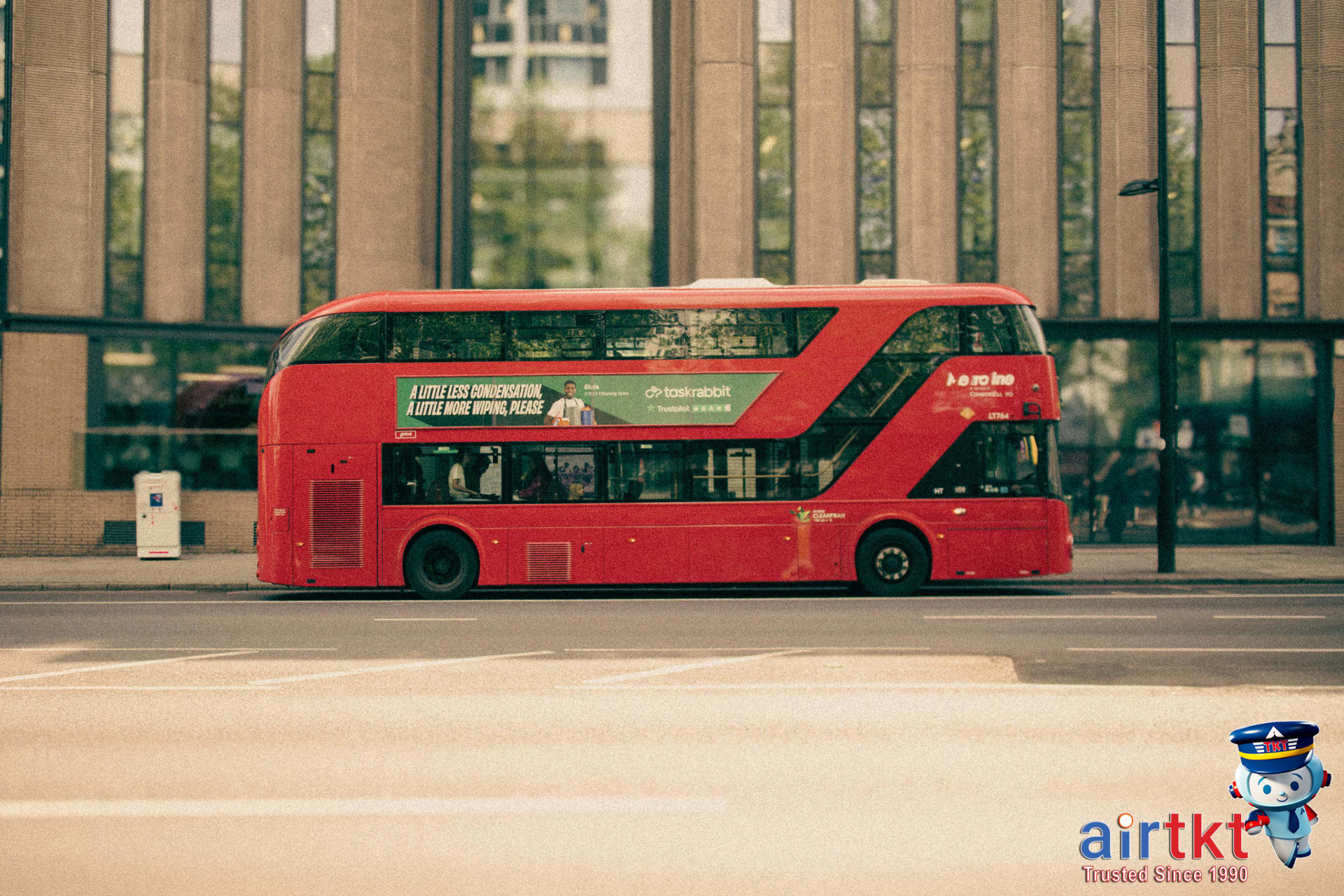 A classic red double-decker bus travels through London streets for visitors