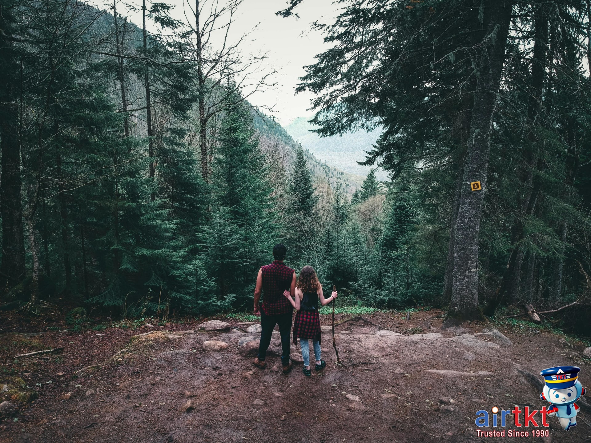 Couple hiking lakeside trail during Victoria Day weekend in Canadian wilderness