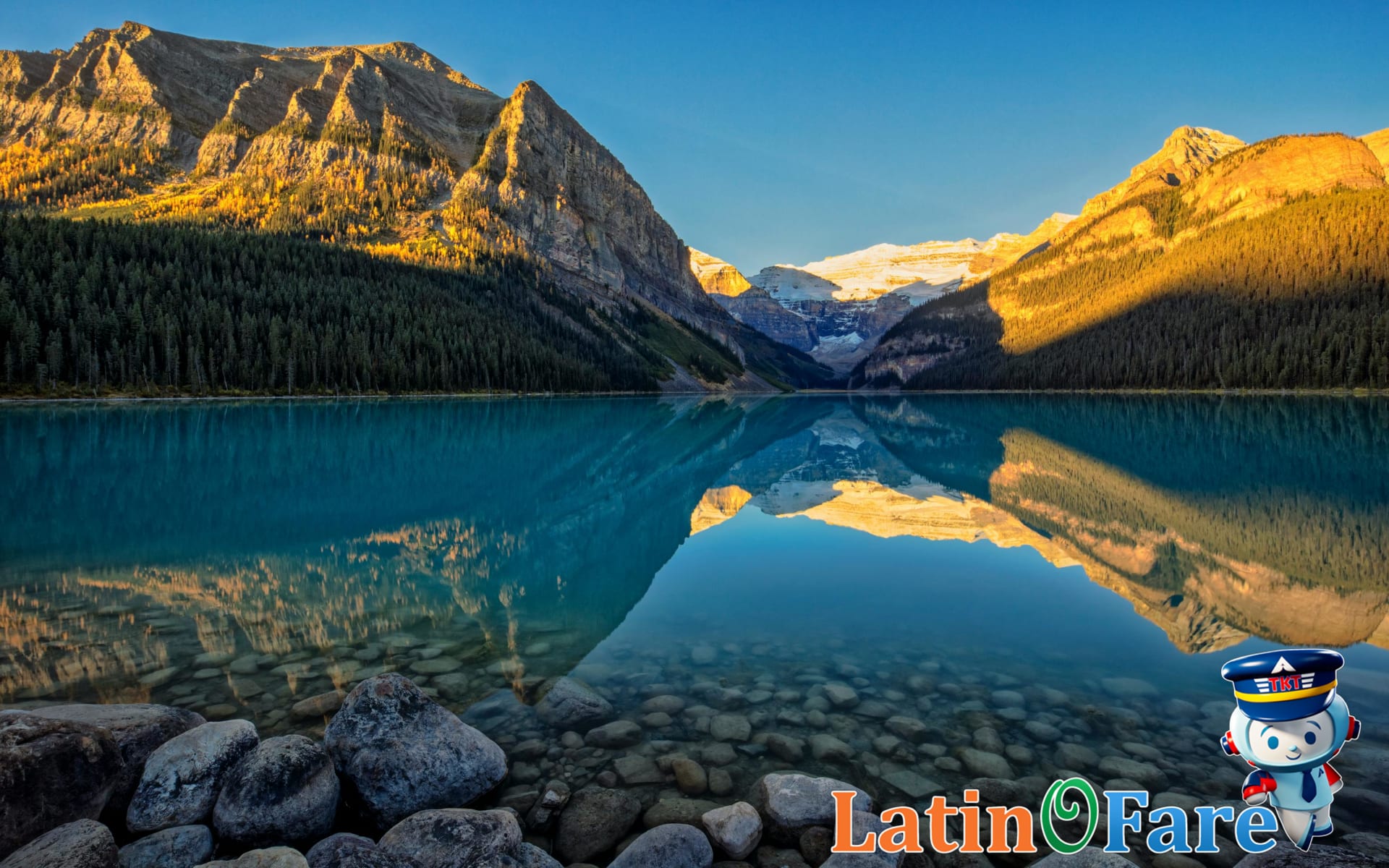Stunning turquoise Lake Louise with snowy peaks in the Canadian Rockies at sunrise.
