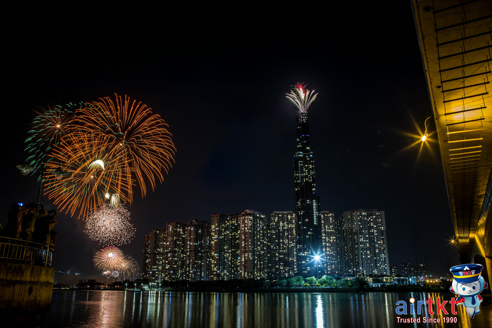 Spectacular Spring Festival fireworks over riverfront city at night