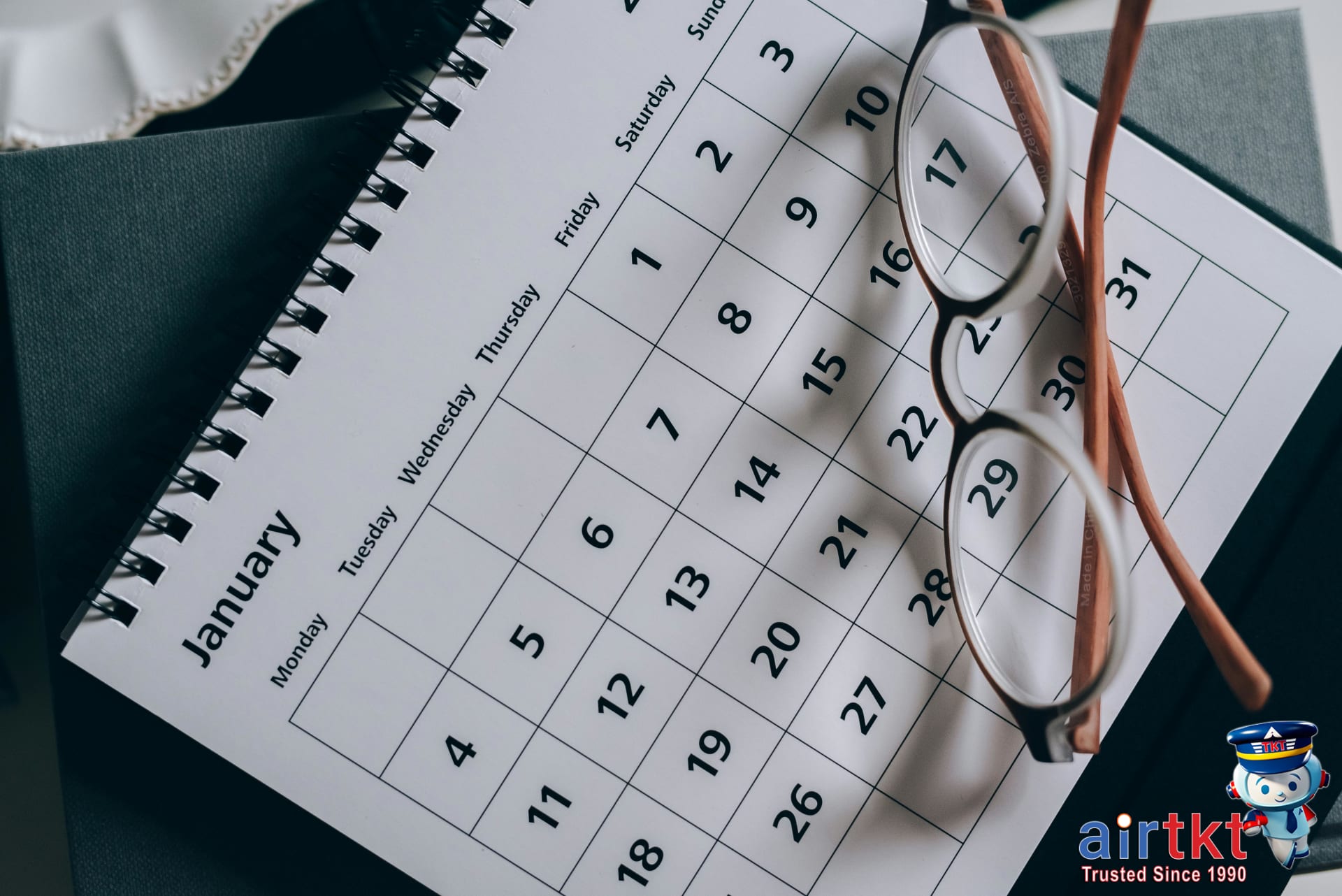 Calendar and eyeglasses on table showing claim submission timing and travel planning