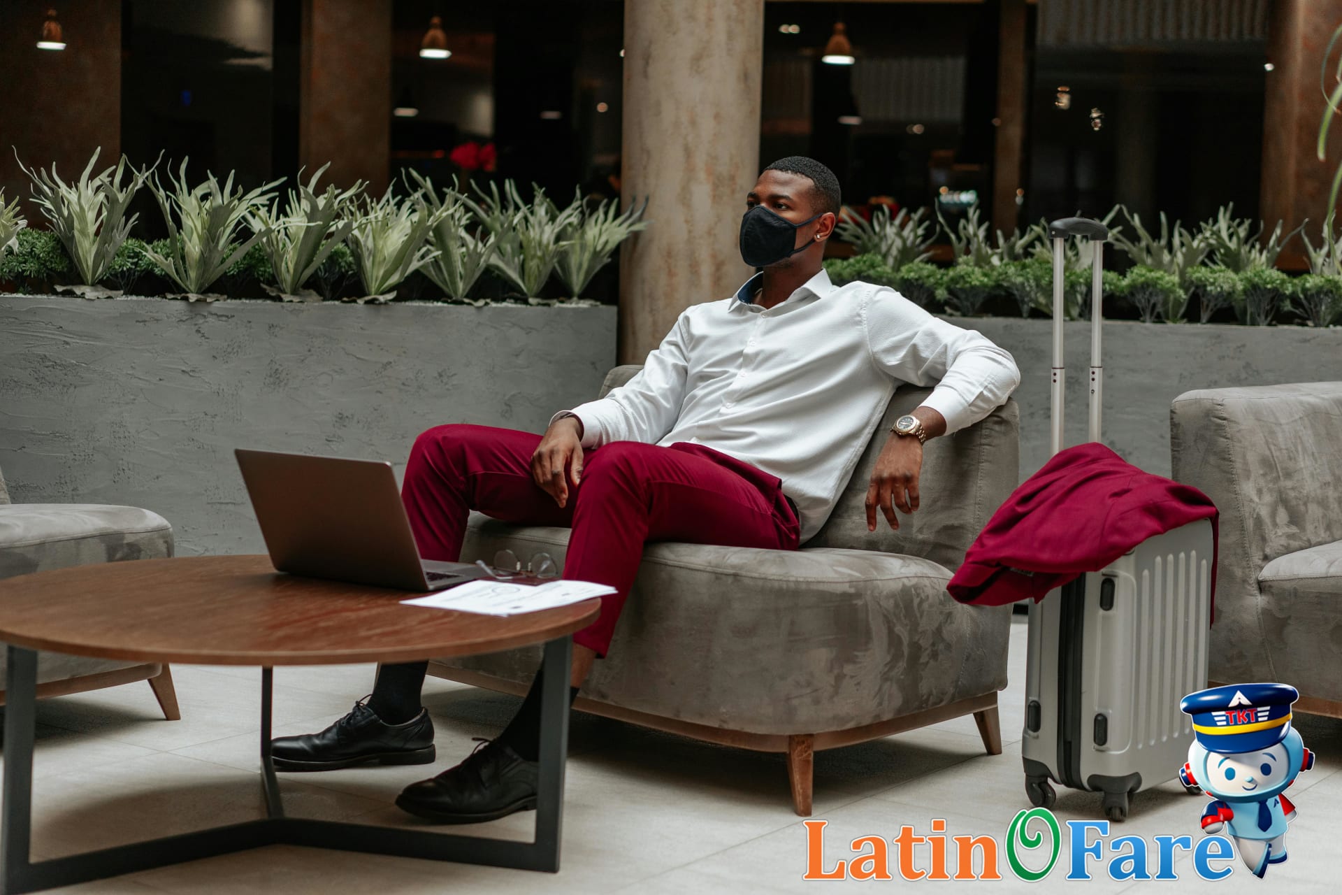 Airport hotel lobby, business traveler using laptop and suitcase, showing hotel benefits for work stays