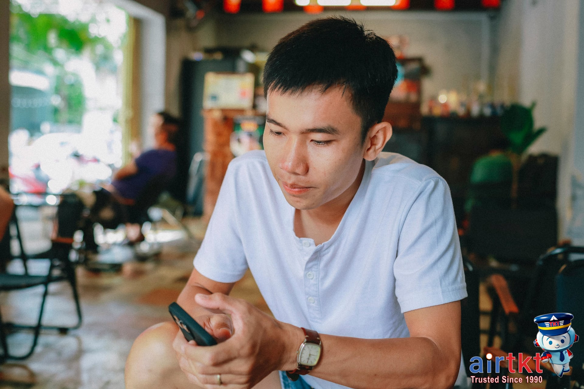 Traveler using smartphone to check travel budget in a Chiang Mai cafe