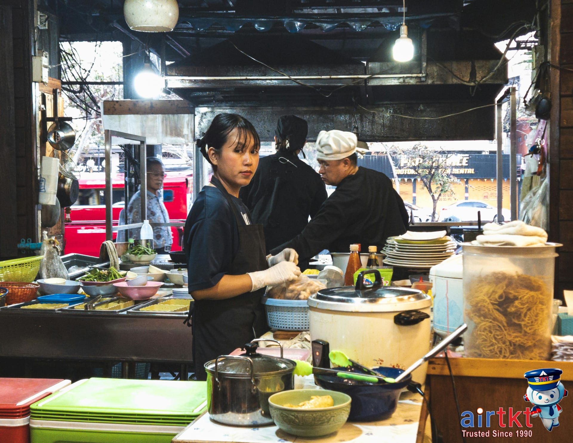 Street food vendors cooking traditional Thai dishes at Chiang Mai market