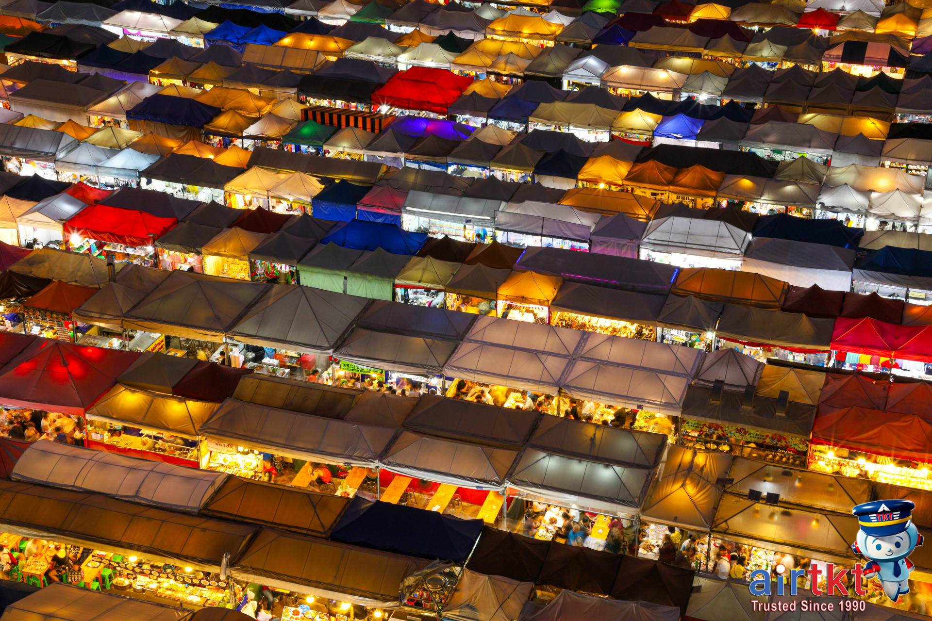 Colorful nighttime vibrant scene at Chiang Mai Night Bazaar market with food stalls and crowds