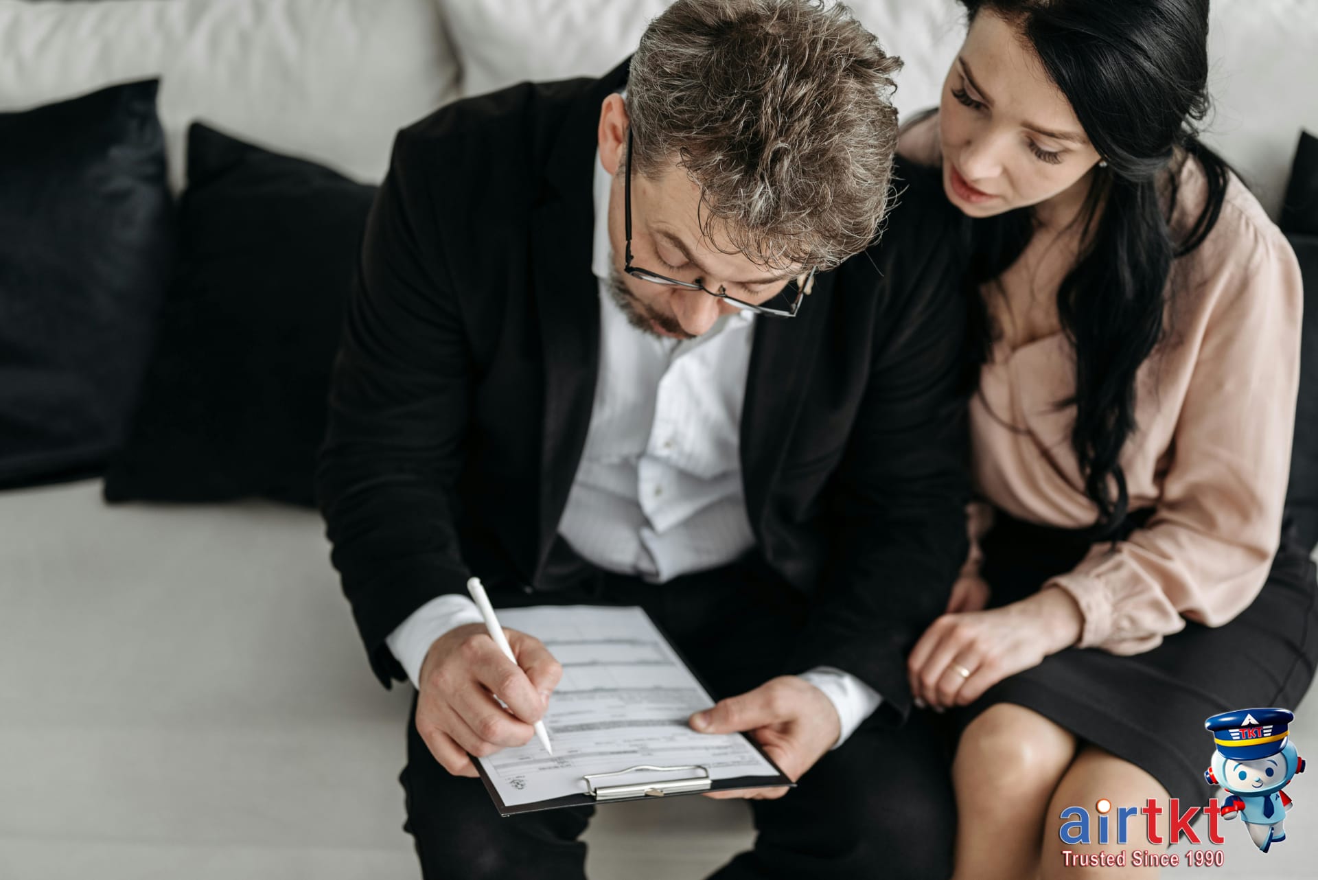 Couple reviewing travel documents and safety tips indoors before trip