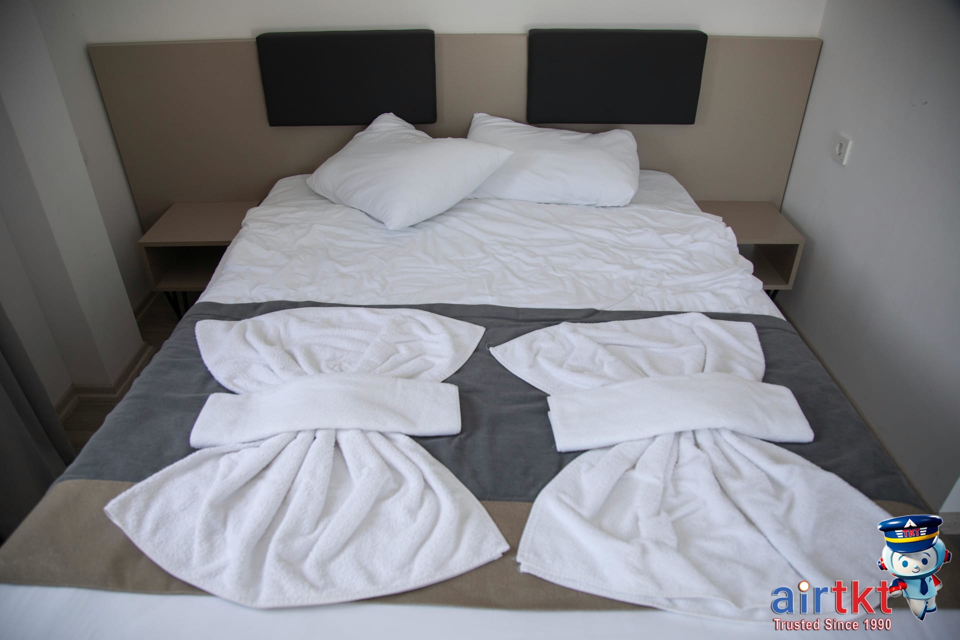 Hotel room with neat bed and decorative towel art showcasing accommodation comfort