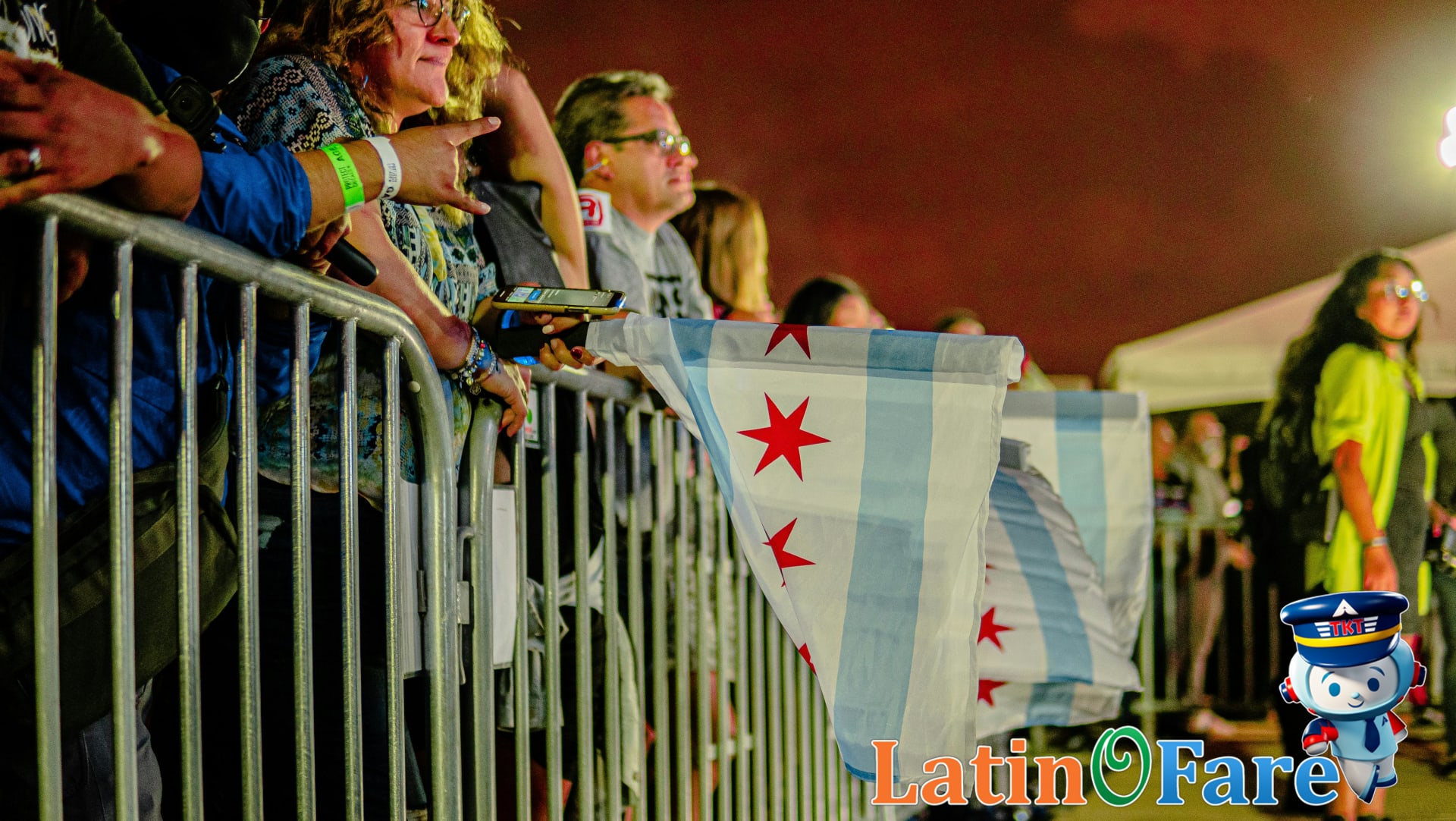 Crowd waving Chicago city flag enjoying Lollapalooza Chicago lineup live music.