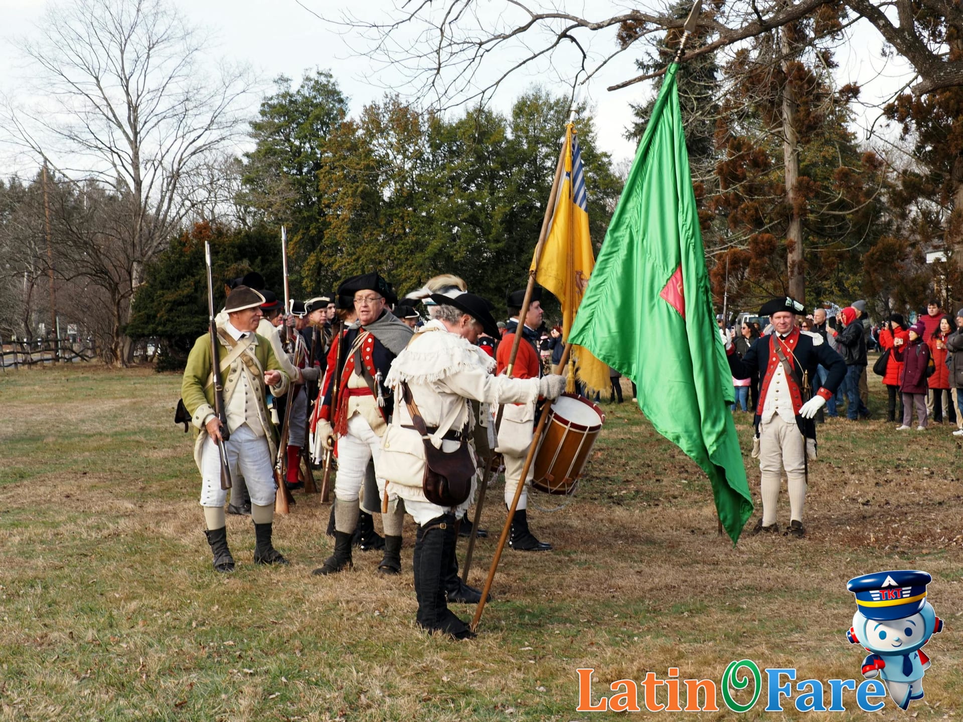 Group raising a US flag together at a historic site during a Flag Day celebration.