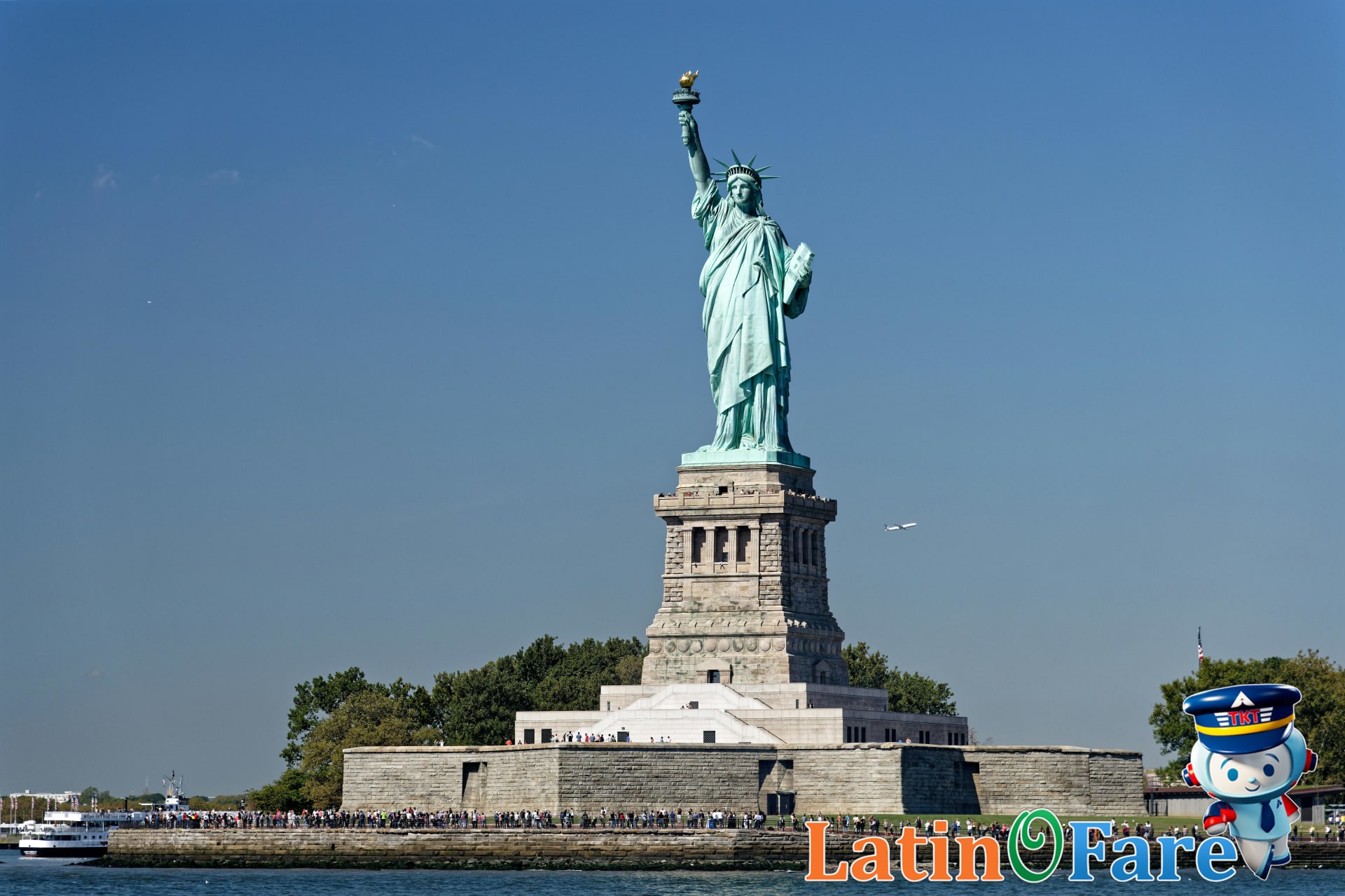 Summer travelers visiting Statue of Liberty monument during Flag Day festivities in the US.