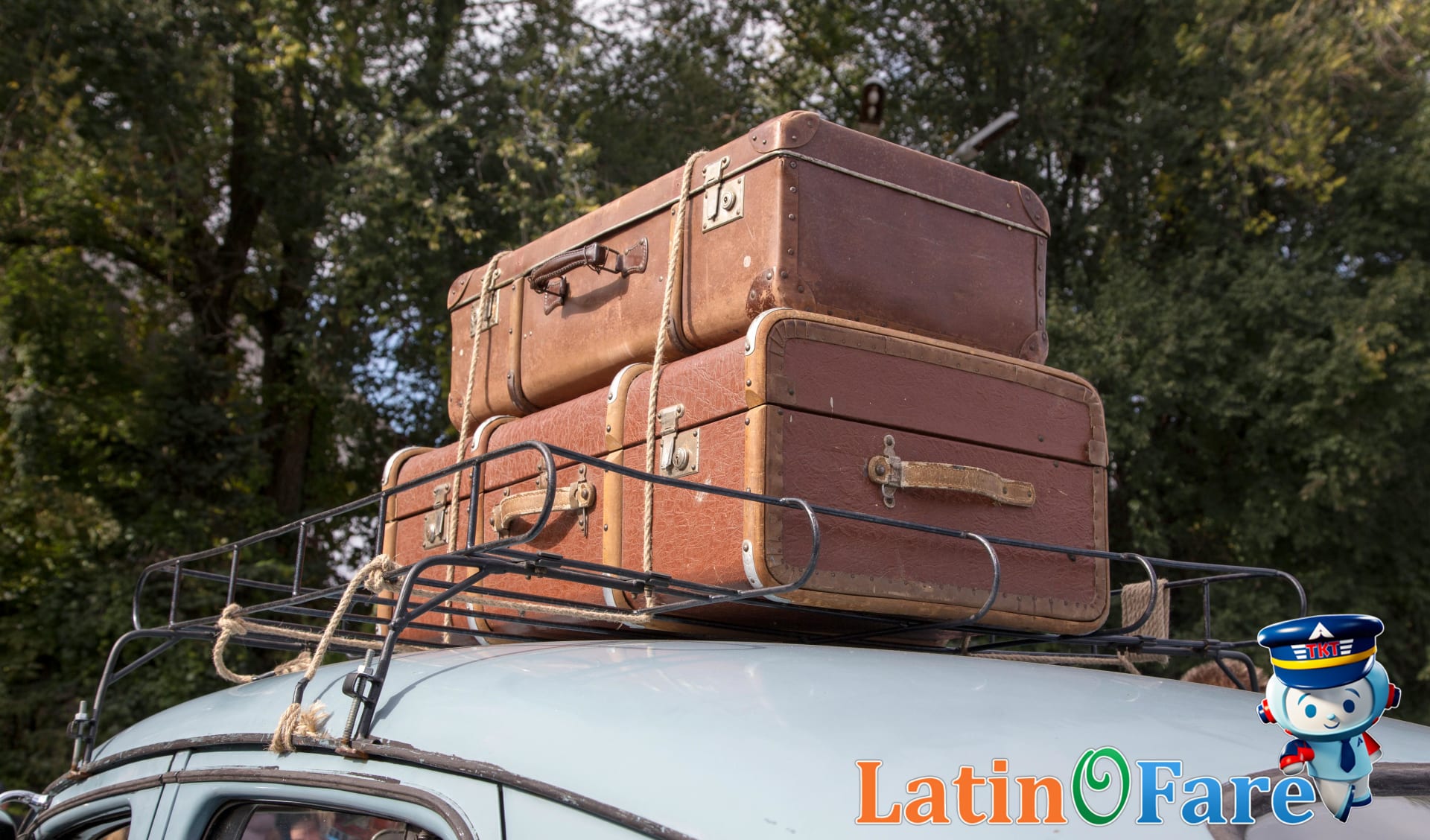 Stack of vintage suitcases on car roof rack for Flag Day road trip adventure