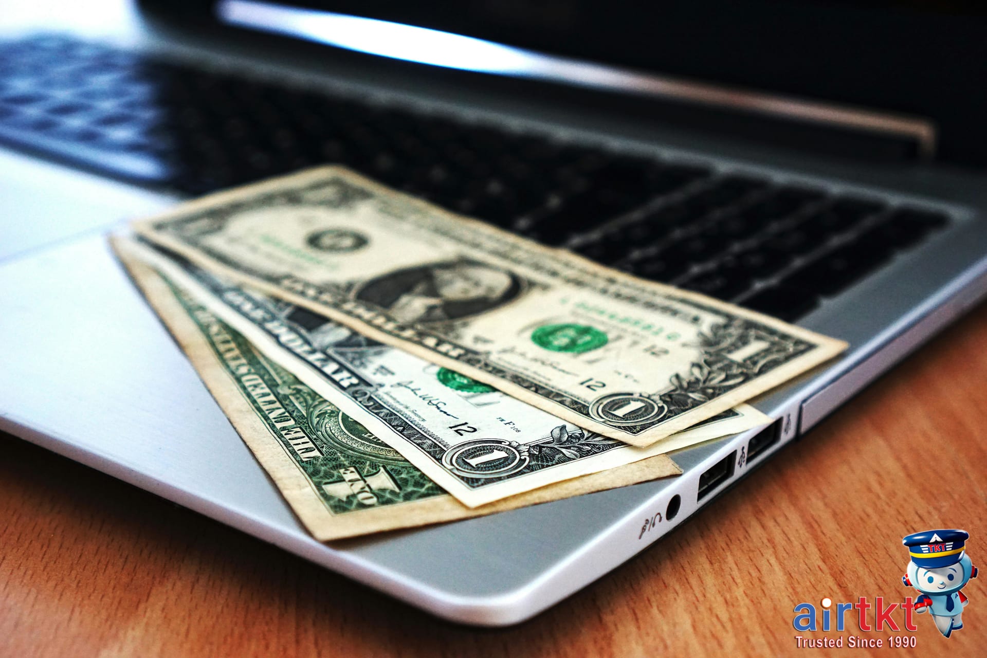 Budget planning for Philippine Independence Day travel with currency and laptop