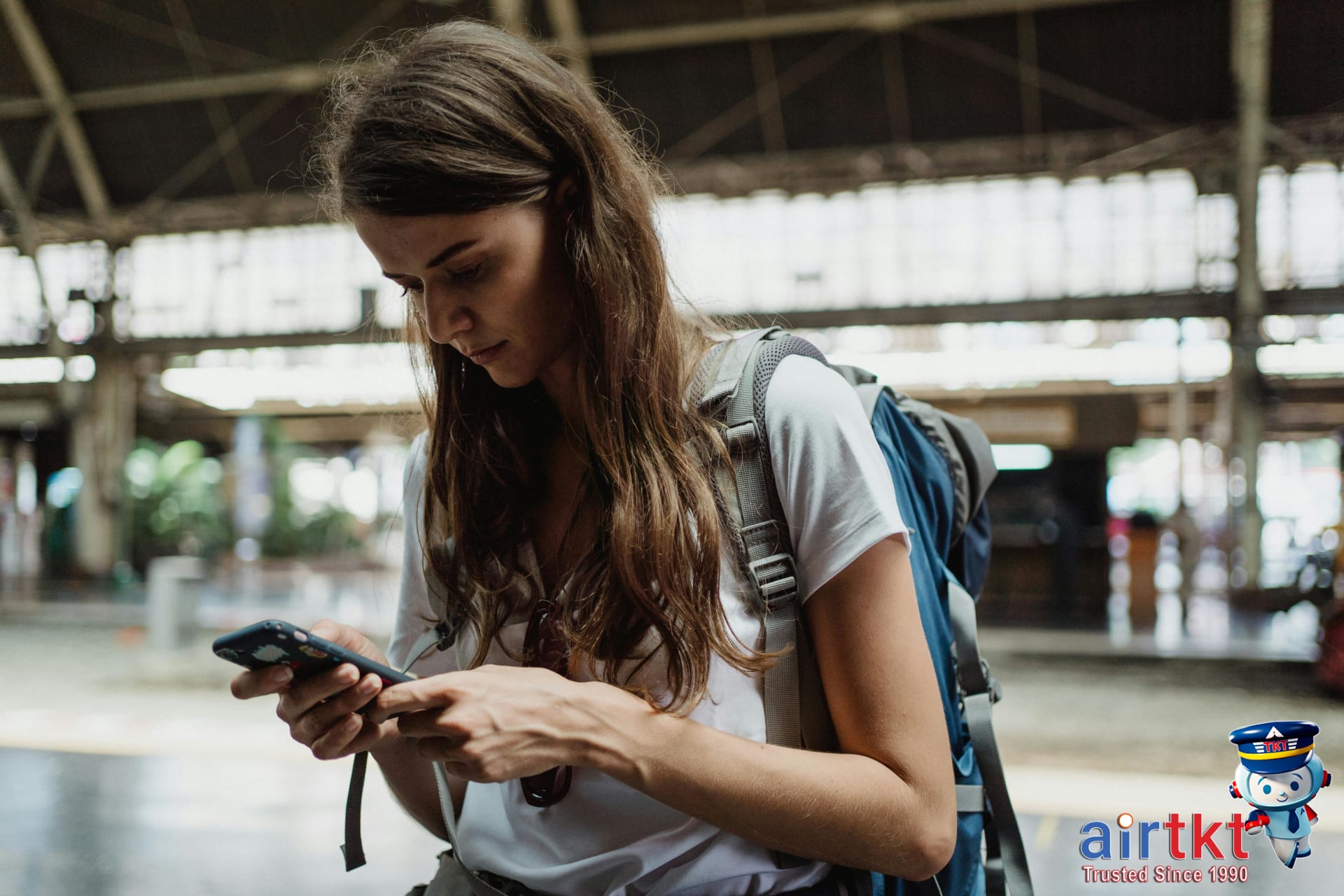 Traveler using OMNY card at NYC subway turnstile while reviewing trip notes