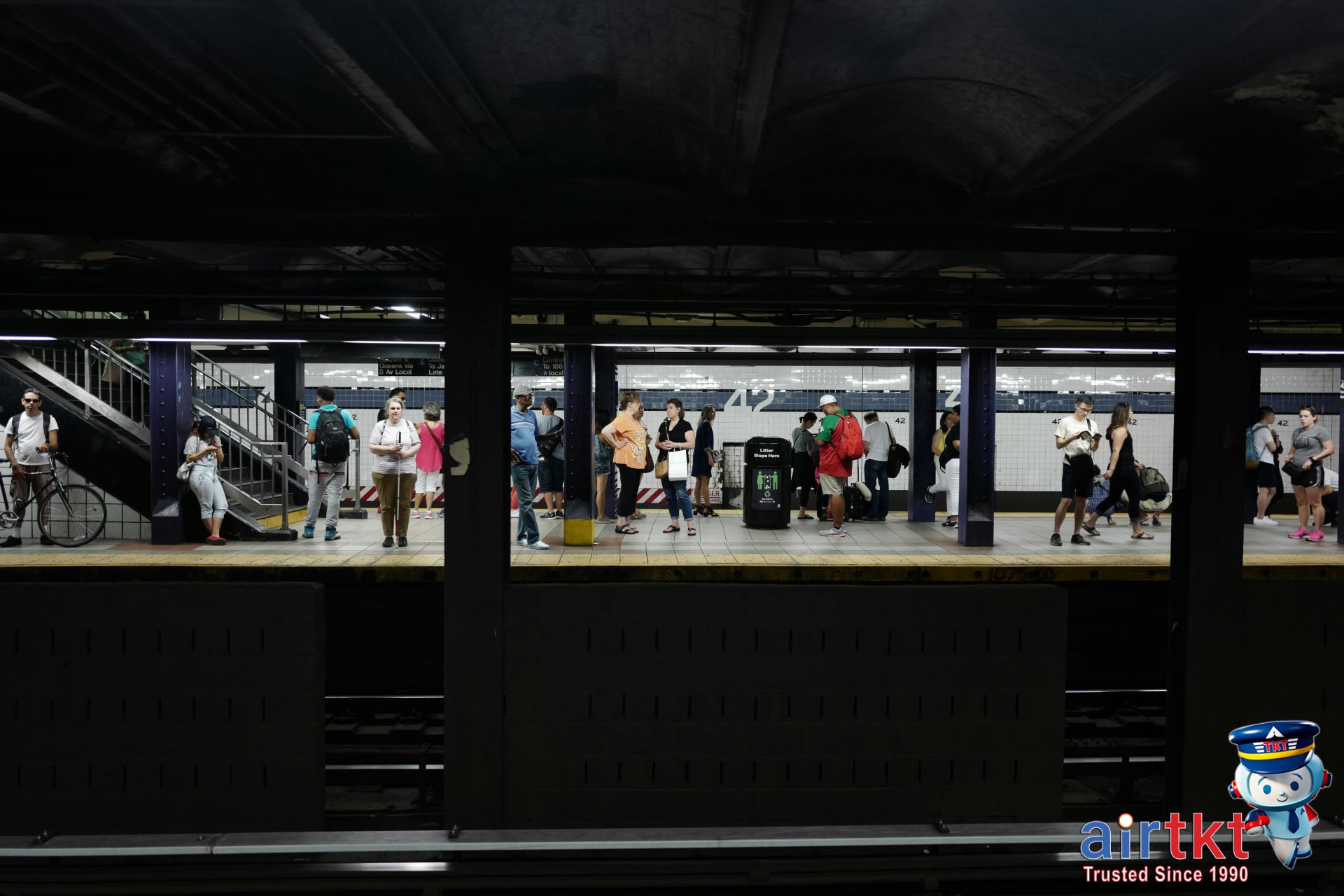 Tourists looking confused at a crowded NYC transit area outside a landmark subway station