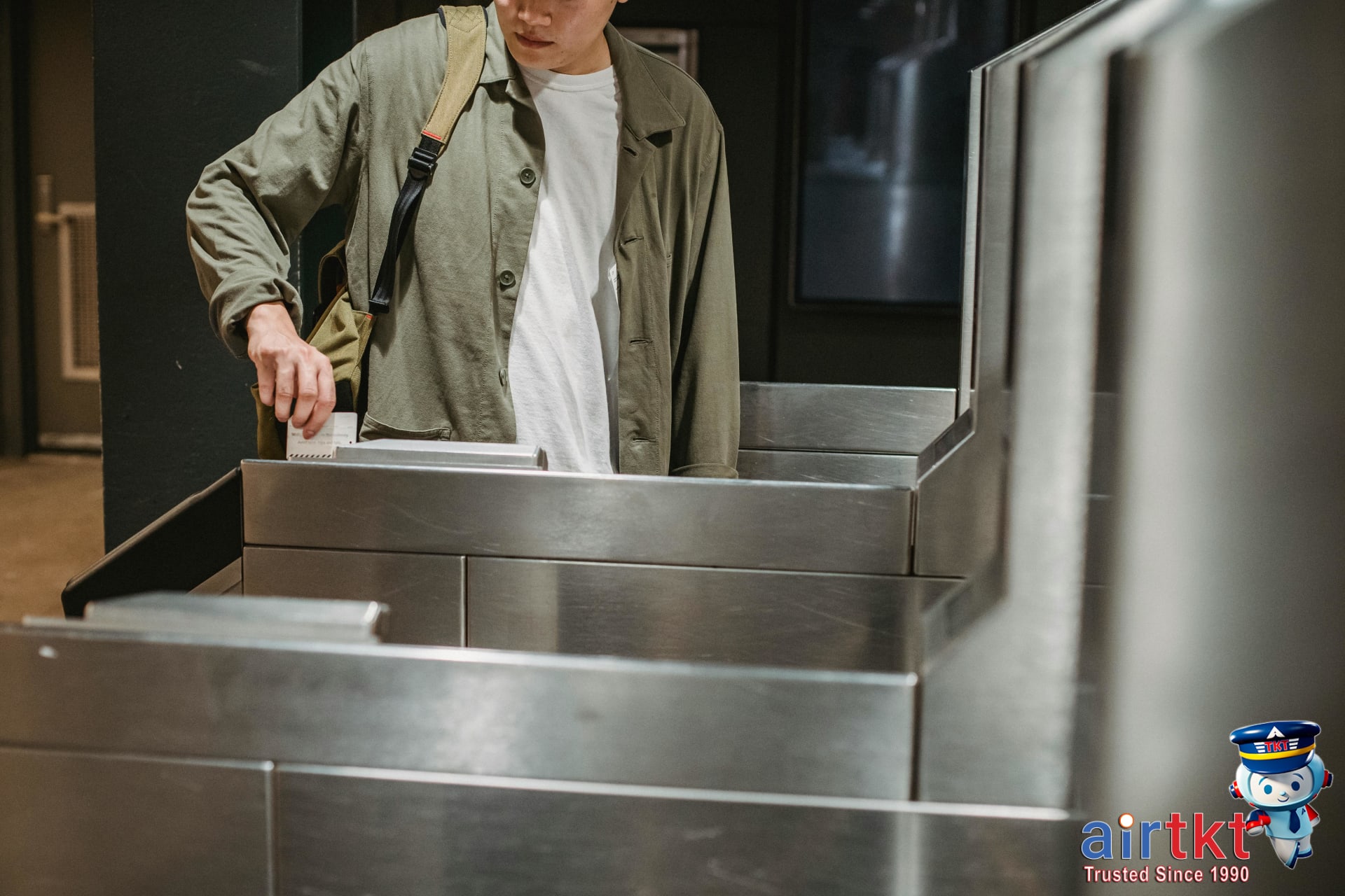 Hand tapping OMNY card at NYC subway turnstile payment reader near entrance