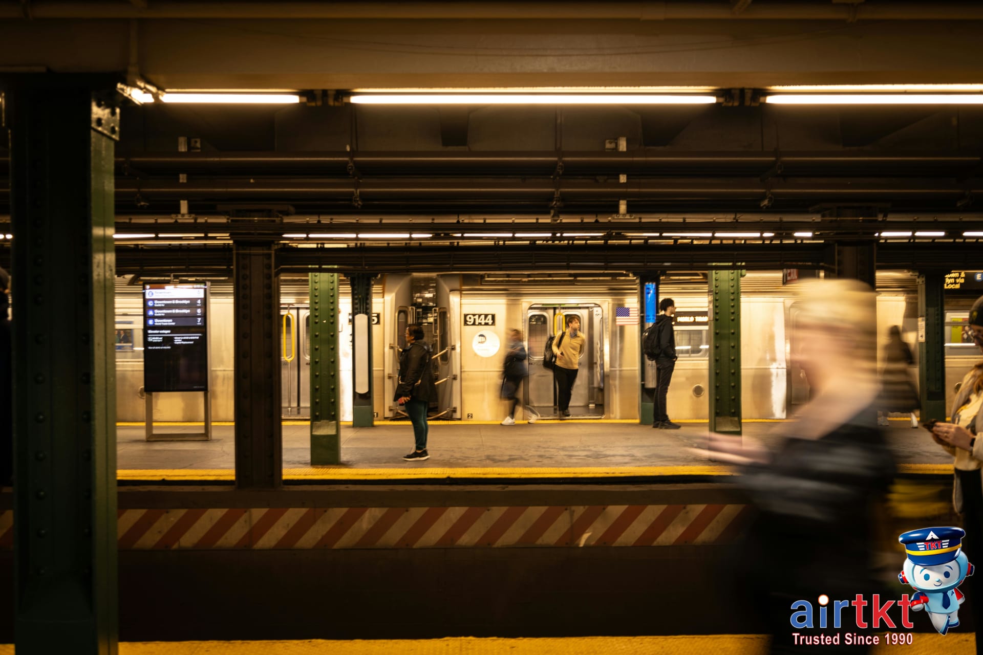 Crowded NYC subway platform with train and commuters using public transport