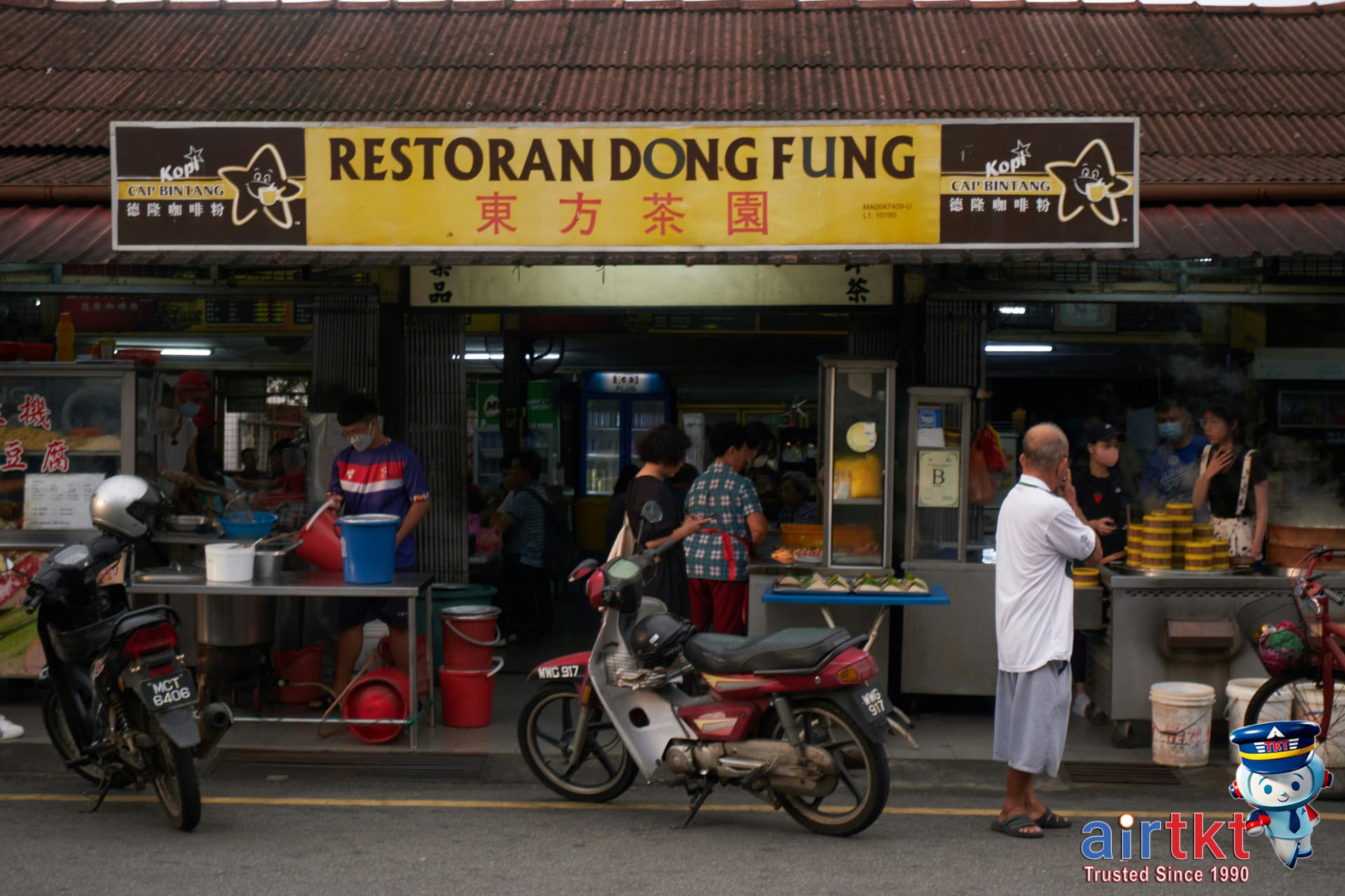 Traveler enjoying inexpensive local cuisine in open-air market setting