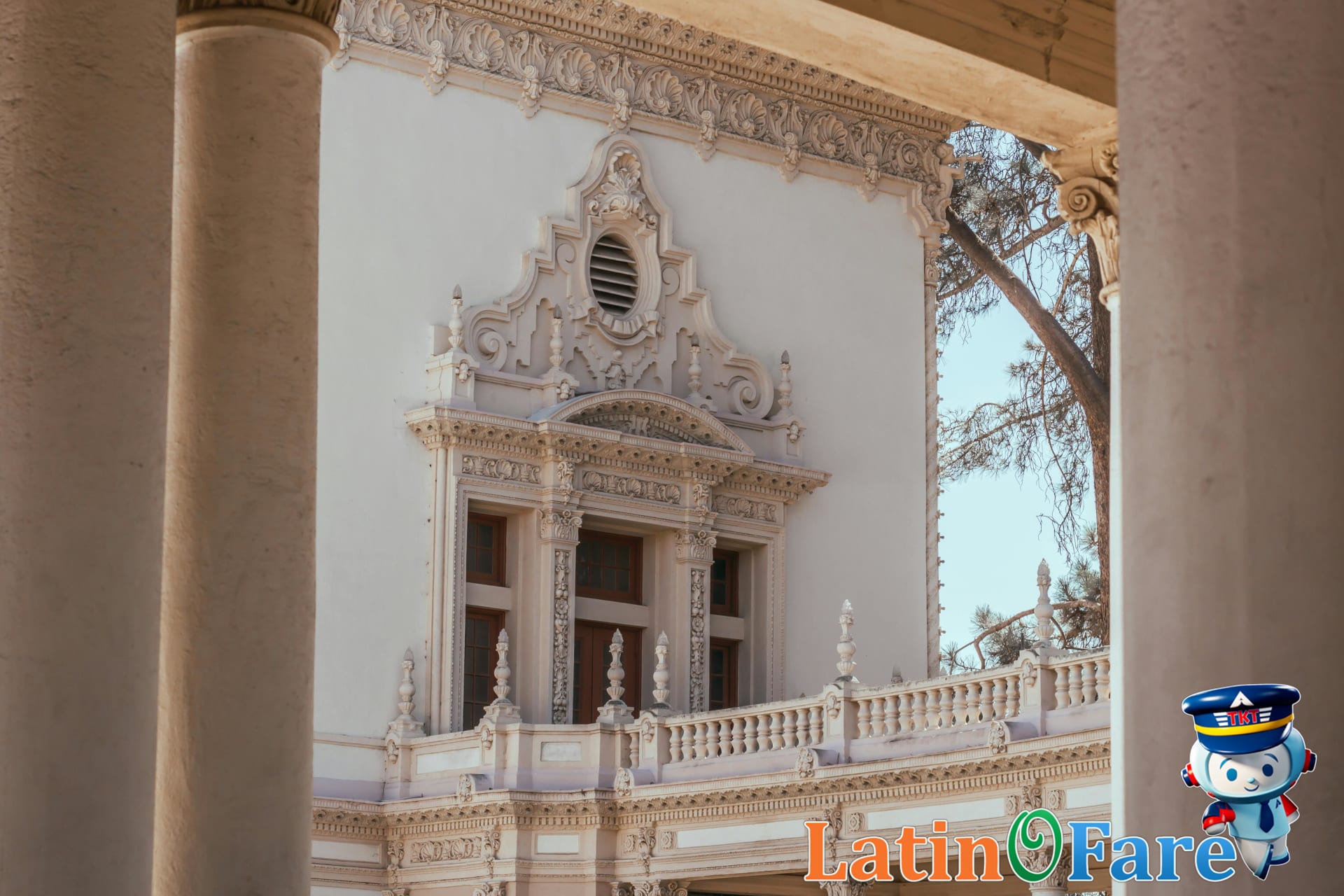 Balboa Park entrance in San Diego with palm trees and Spanish Revival buildings saves you money.