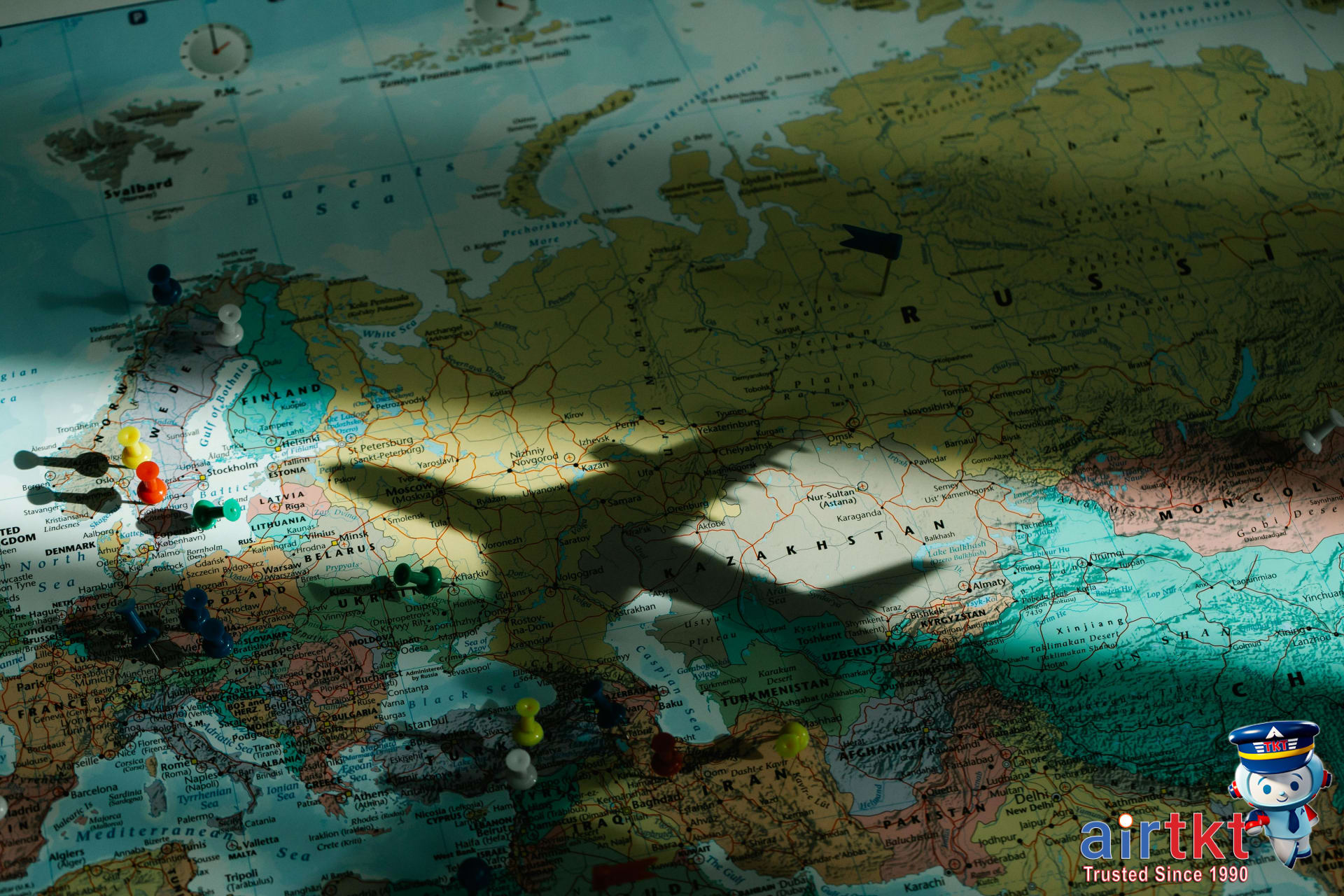 Shadow of an airplane on a map showing open jaw flight route for travelers
