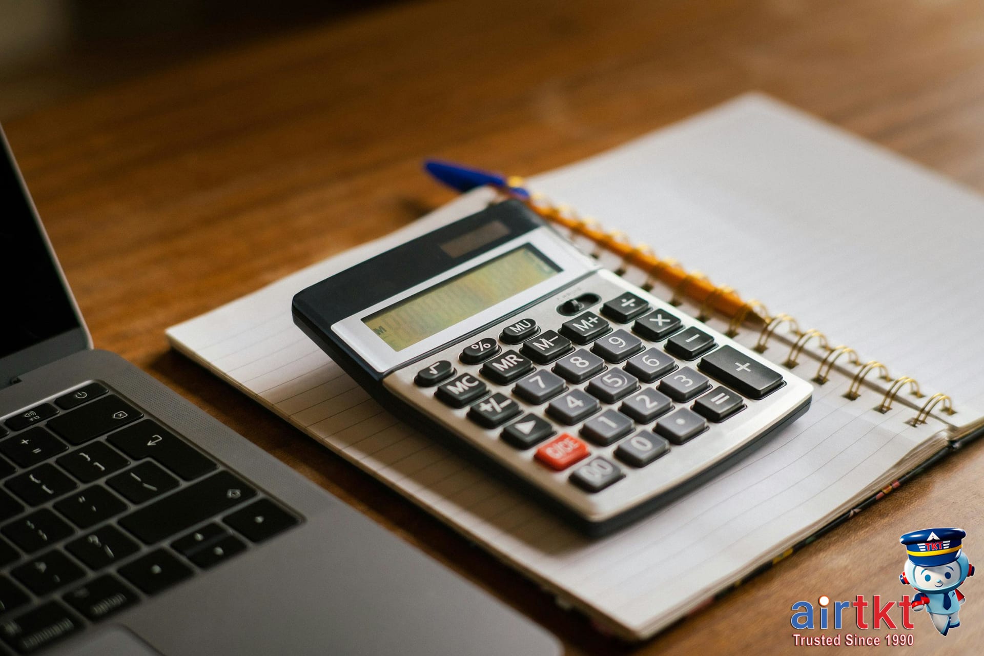 Budget planning for Juneteenth travel trip with laptop and calculator.