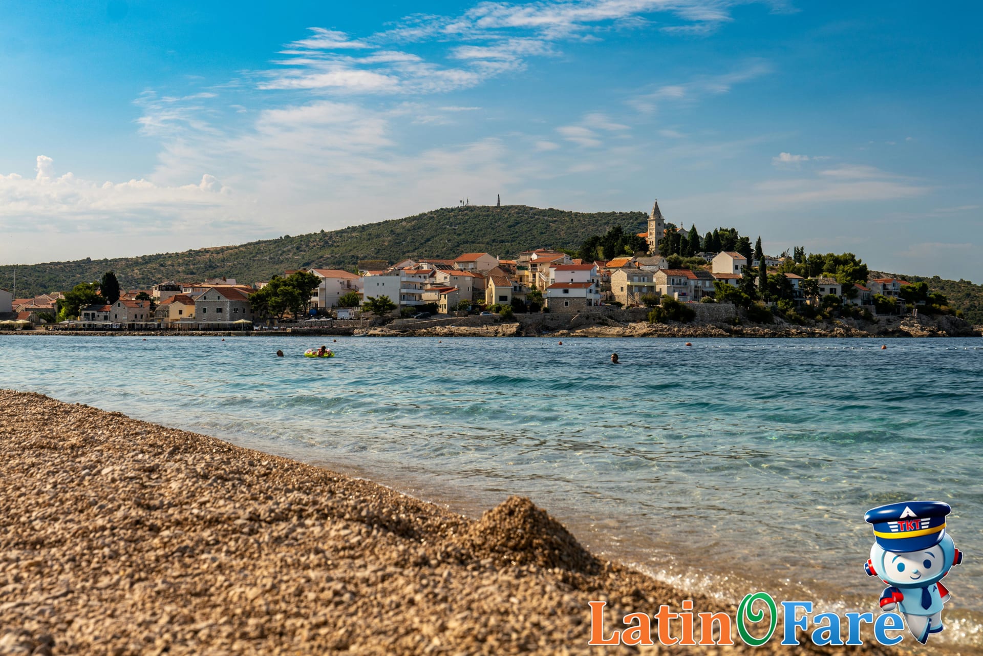 Secluded Croatian Mediterranean beach with green water and pebbled shore, perfect for quiet summer vacations.