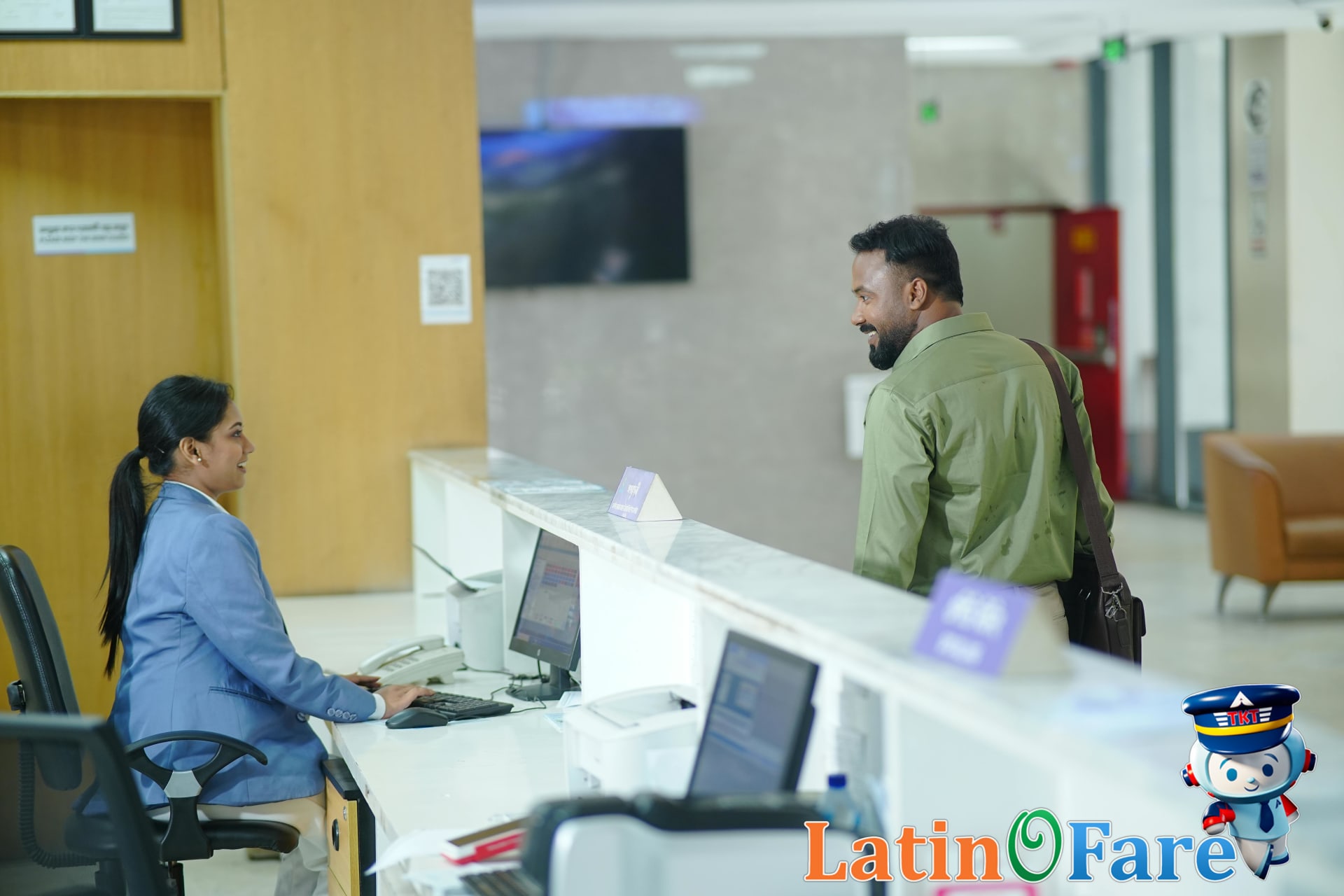 Hotel front desk agent assisting guest with price matching guarantee support process.