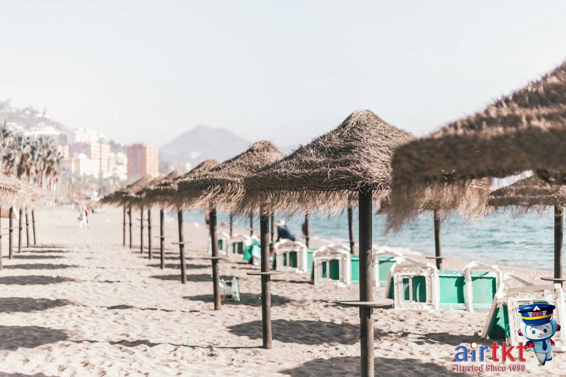 Spanish Mediterranean sandy beach with sun umbrellas and beachgoers enjoying summer