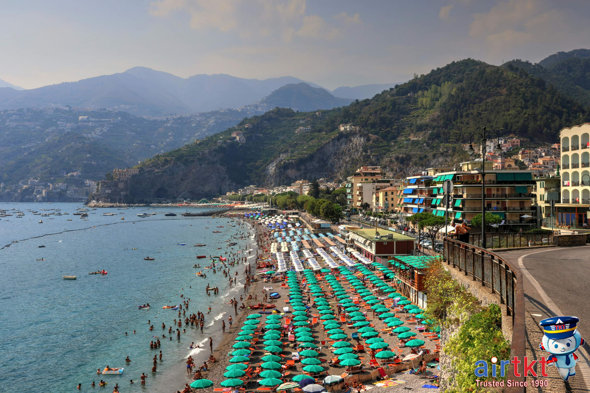Panoramic Mediterranean coastline beach with colorful umbrellas and sunbathers enjoying summer