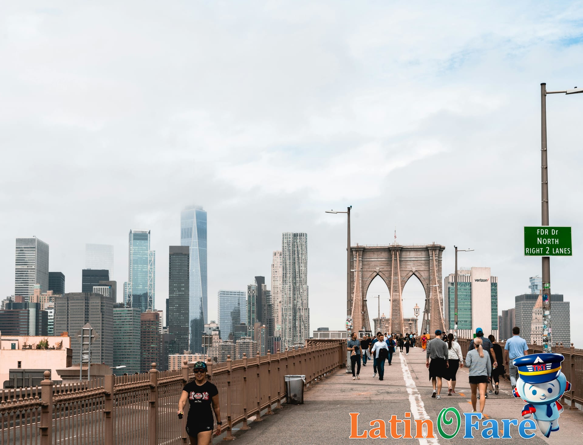 Tourists walking the Brooklyn Bridge enjoying free New York City sights.