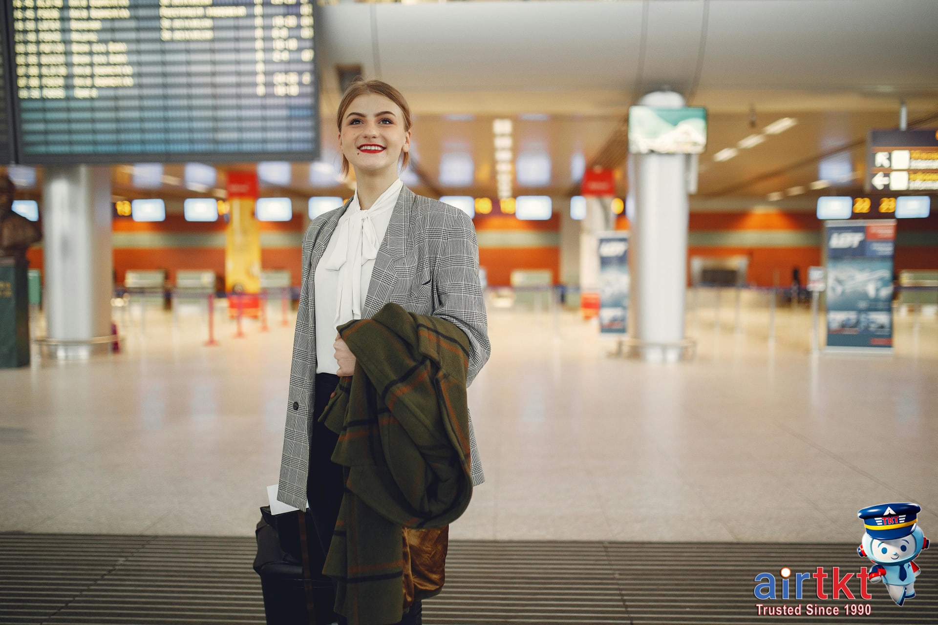 Smiling traveler confident about airline passenger rights with luggage