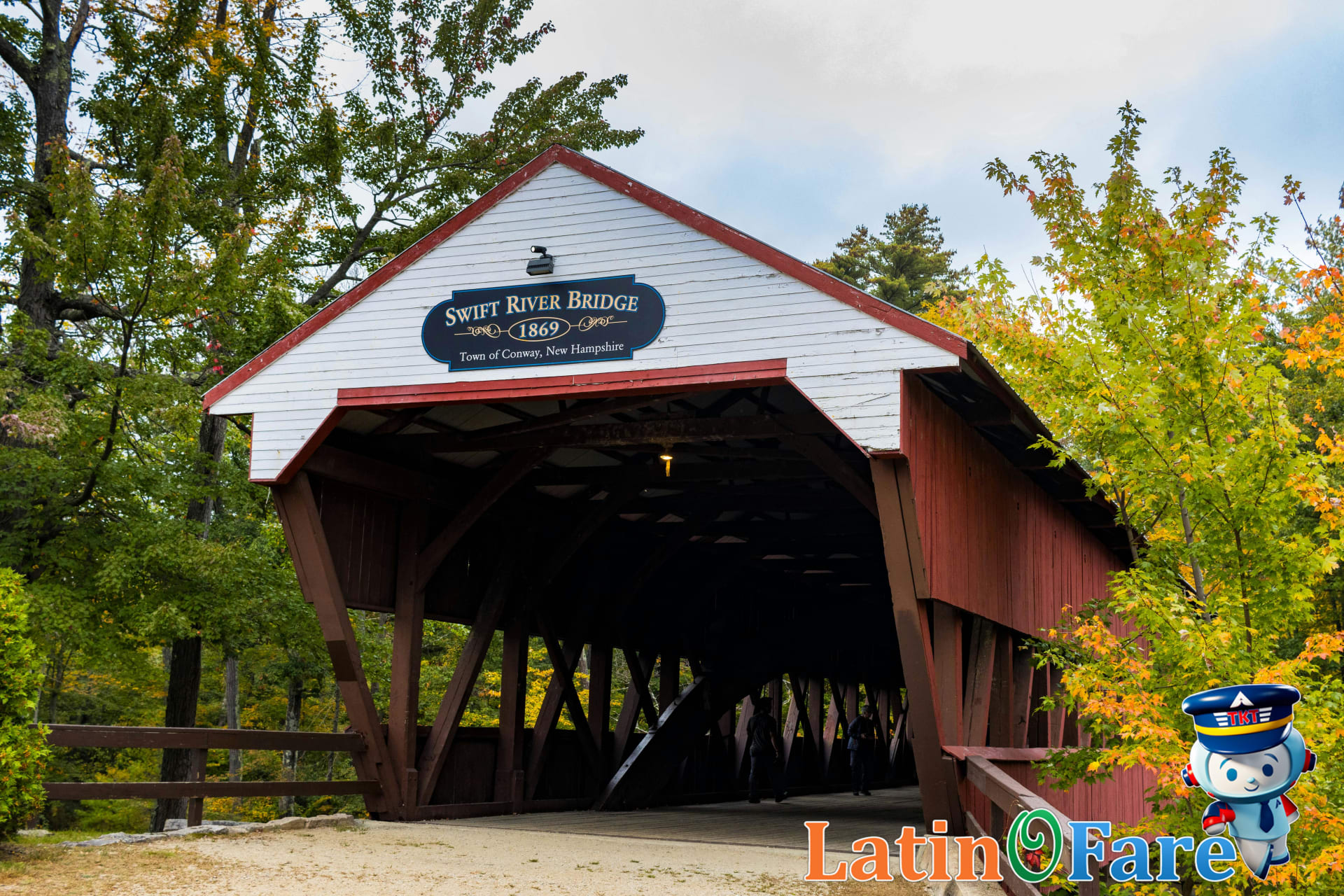 Family at covered bridge in New England enjoying fall foliage and vibrant autumn colors together.
