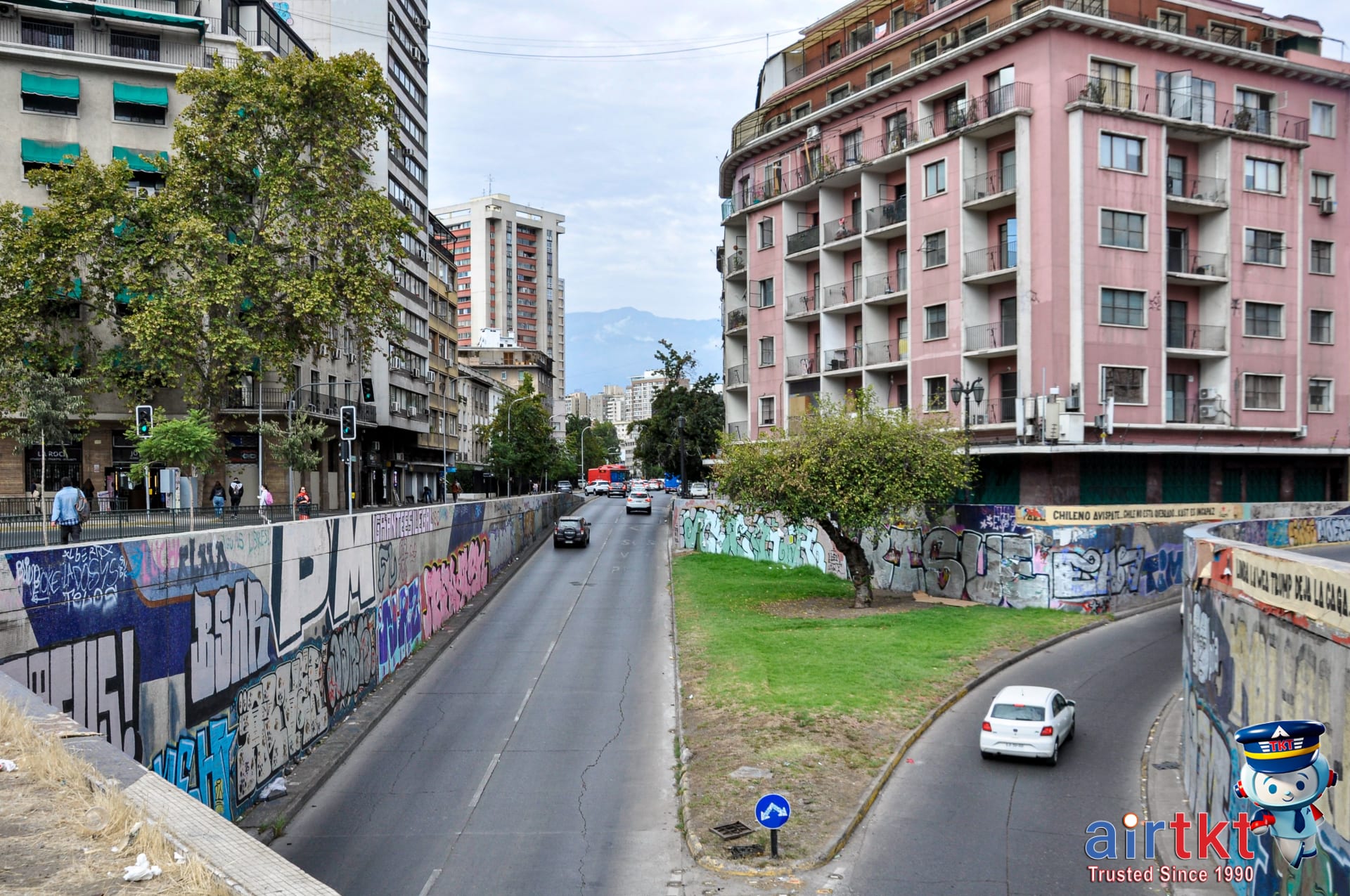 Bustling Santiago city street with Andes mountains in the background daytime