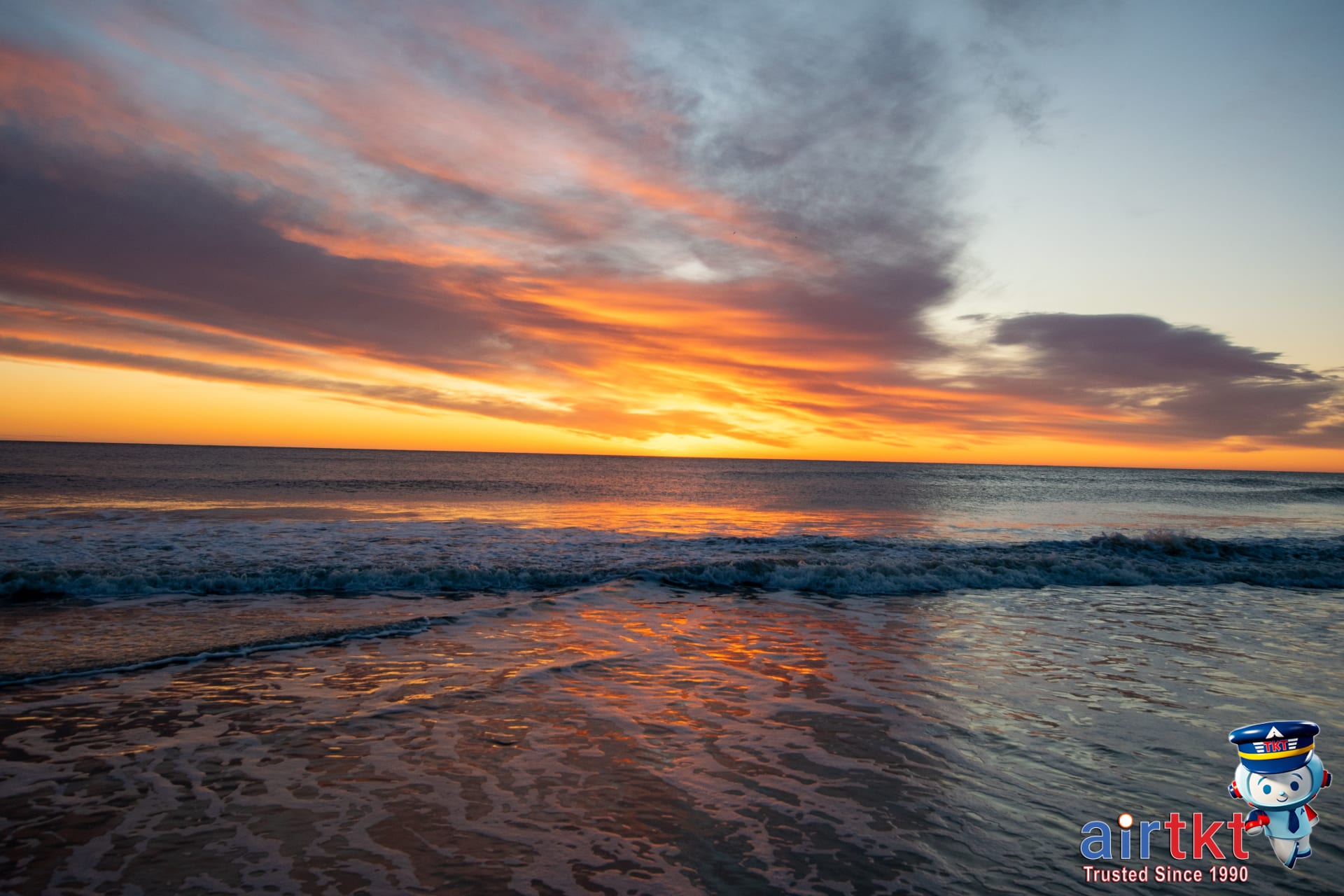Sunset over Cape Cod beach with vibrant ocean waves and sandy shore