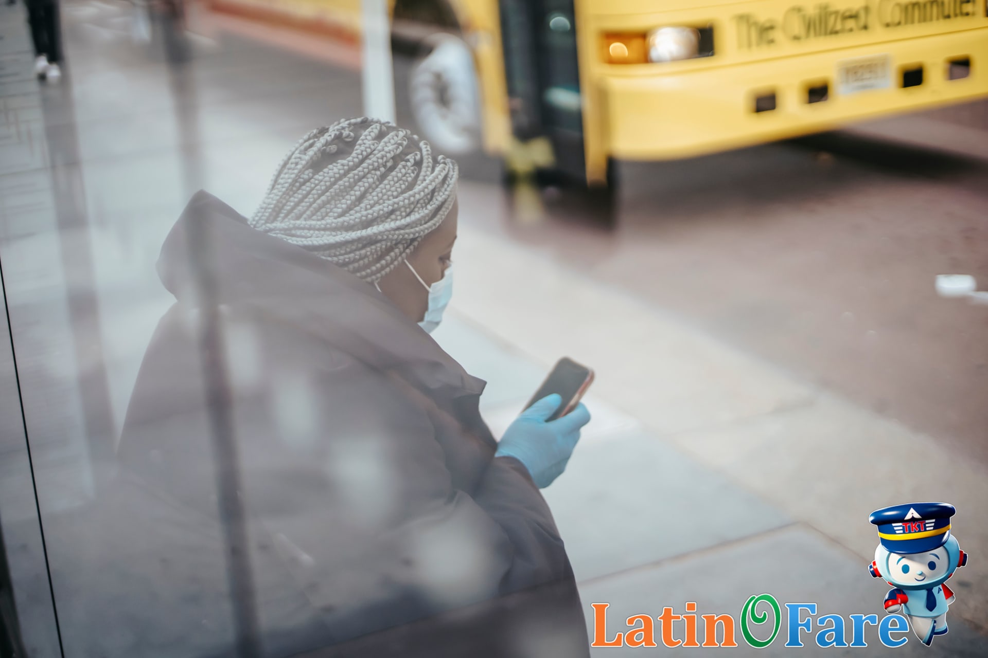 Traveler using WMATA mobile app at a DC bus stop to plan Metro and bus routes.