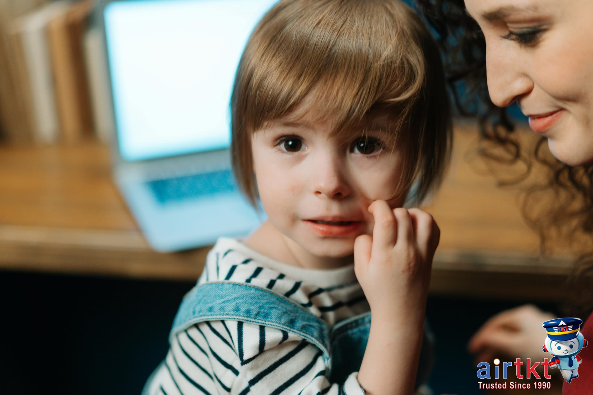 Family travel Q&A with parent and child smiling at an airport information counter