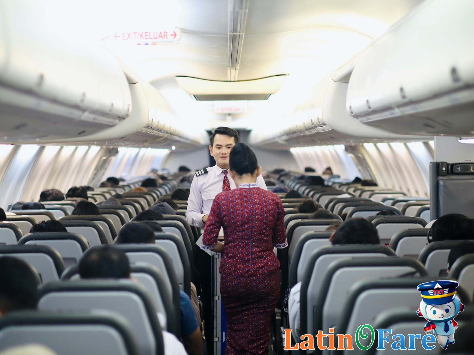 Flight crew quietly serving passengers in a darkened overnight airplane cabin on red-eye flight
