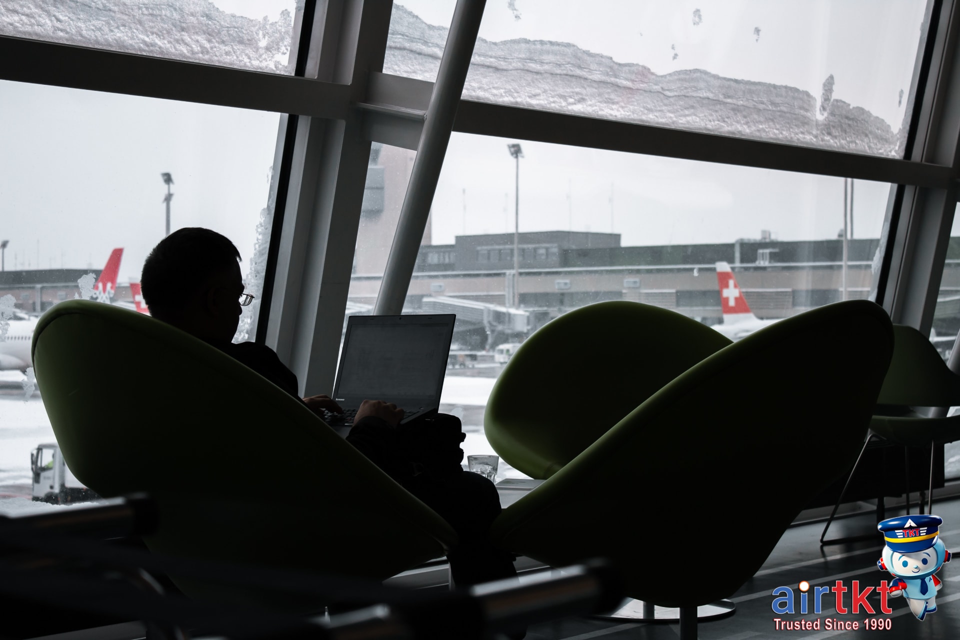 Budget traveler booking United Airlines flights with laptop and MileagePlus account open