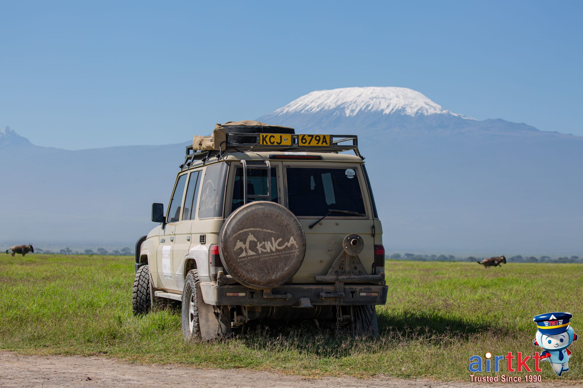 Land Cruiser SUV parked on grasslands near Kenya and Tanzania safari parks map.