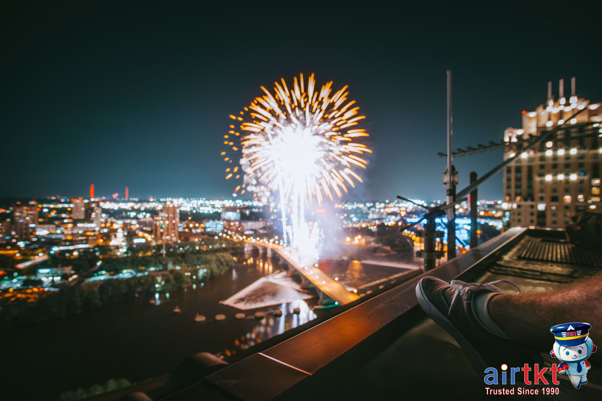 Family enjoying Fourth of July fireworks from rooftop overlooking city